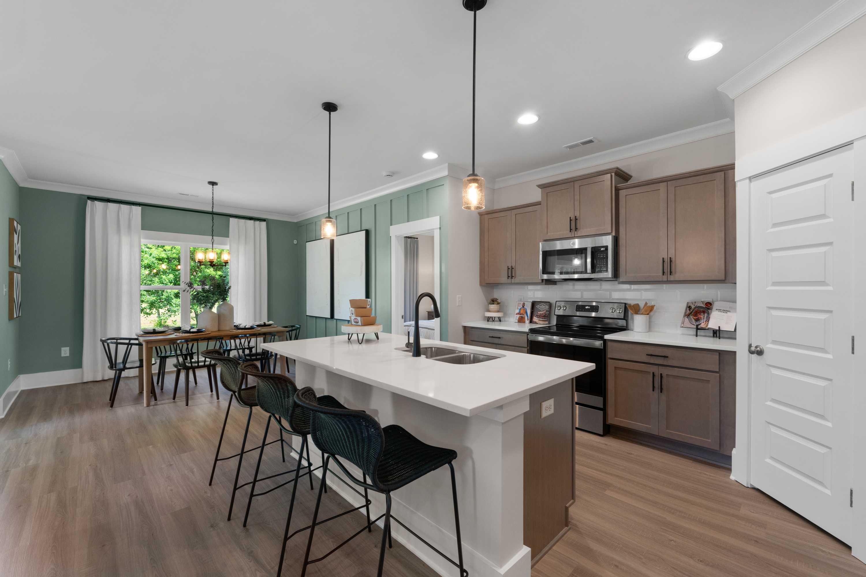 Modern open-concept kitchen at Hollon Meadow in Decatur AL with quartz island, shaker cabinets, and hardwood floors