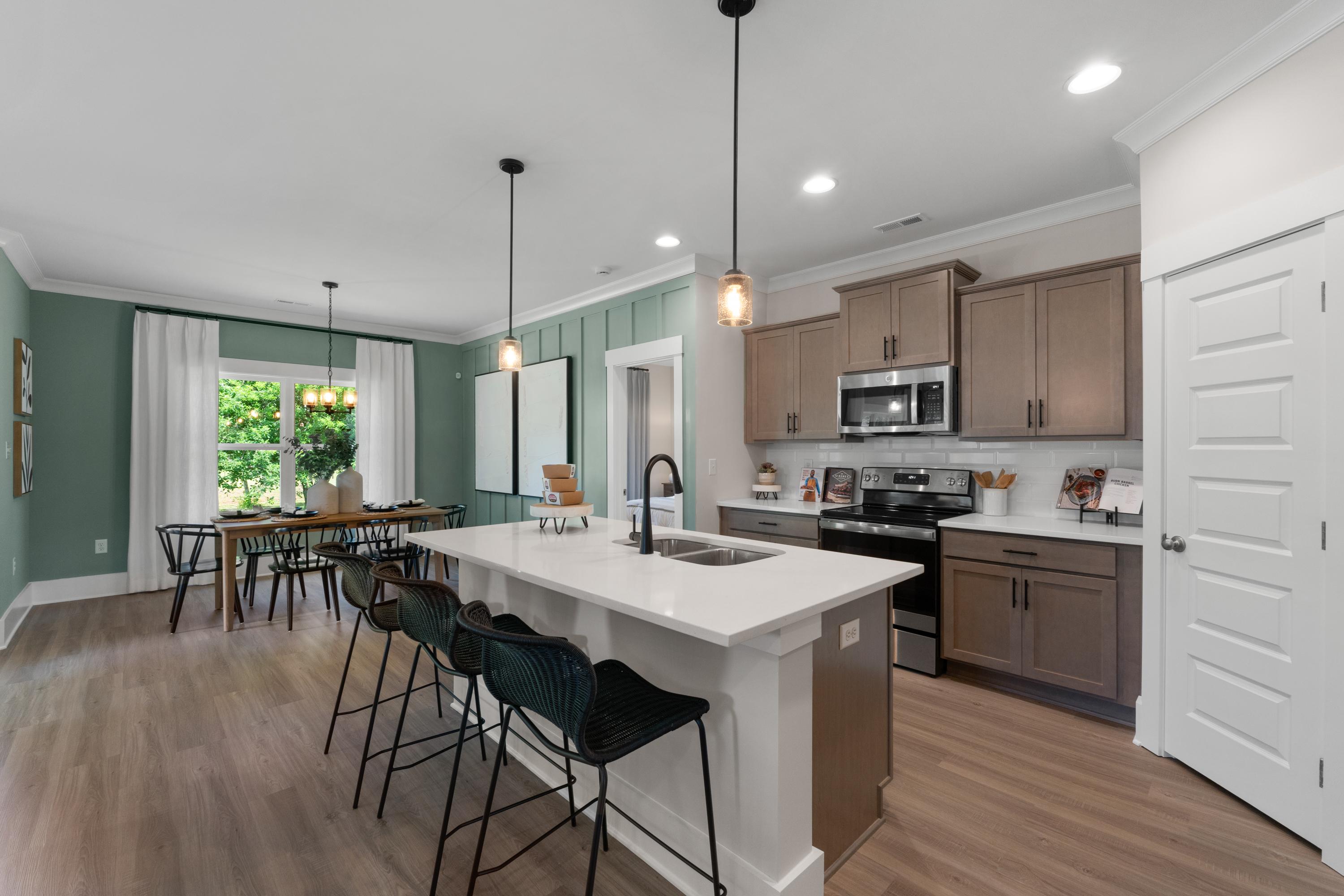 Modern open-concept kitchen at Hollon Meadow in Decatur AL with quartz island, shaker cabinets, and hardwood floors