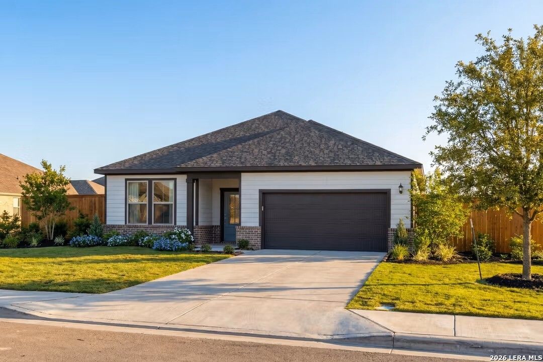 Modern single-story 3-bedroom Davidson Homes Glenwood D with 2-car garage, brick accents, and manicured lawn in Elmendorf, Texas