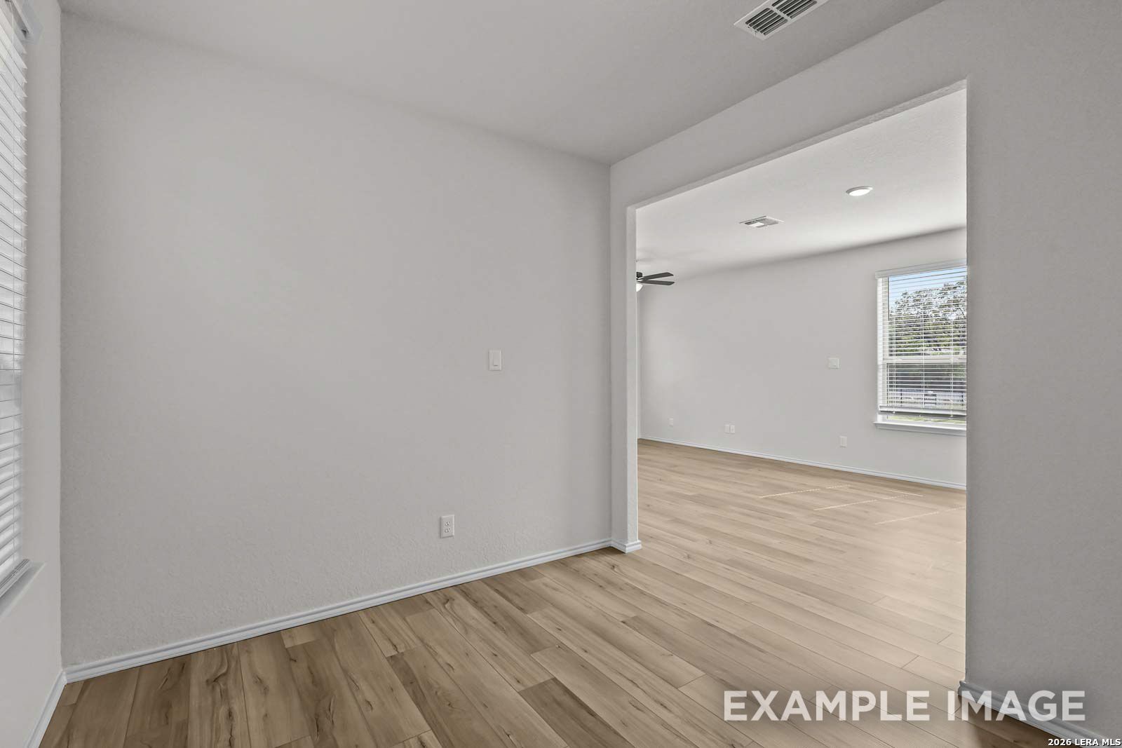 Bright, open-concept living area with wood-style flooring in The Florence D floor plan at Cedar Heights, San Antonio.
