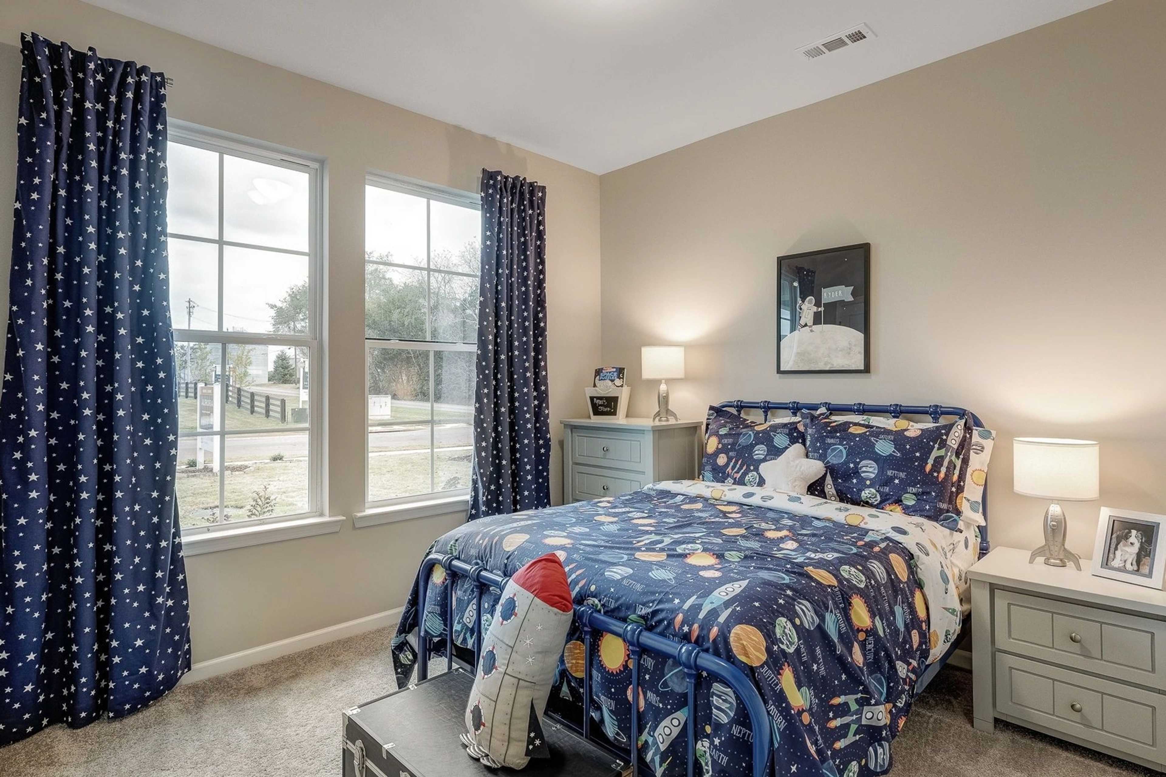 Children's space-themed bedroom in Carroll Green Harvest Alabama with rocket bedding, blue starry curtains, and large windows