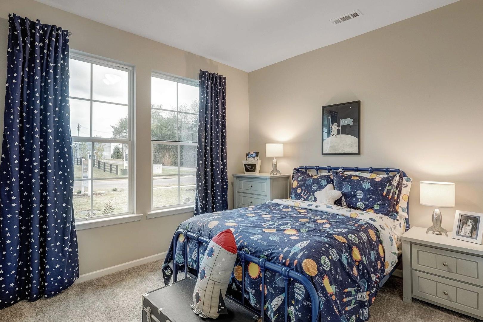 Children's space-themed bedroom in Carroll Green Harvest Alabama with rocket bedding, blue starry curtains, and large windows