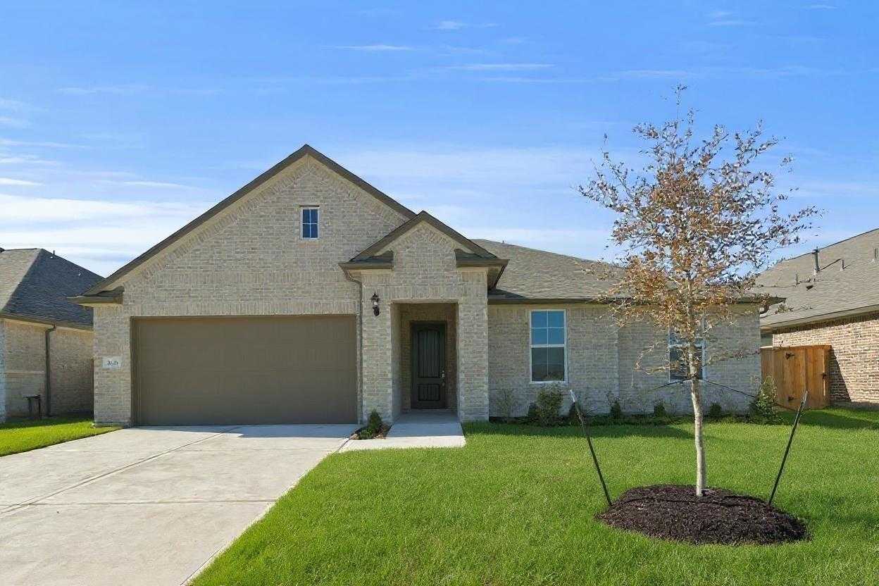 Modern beige brick single-story home with 2-car garage, driveway, and lush front lawn in Lago Mar, Texas City, Texas - Davidson Homes The Diana A