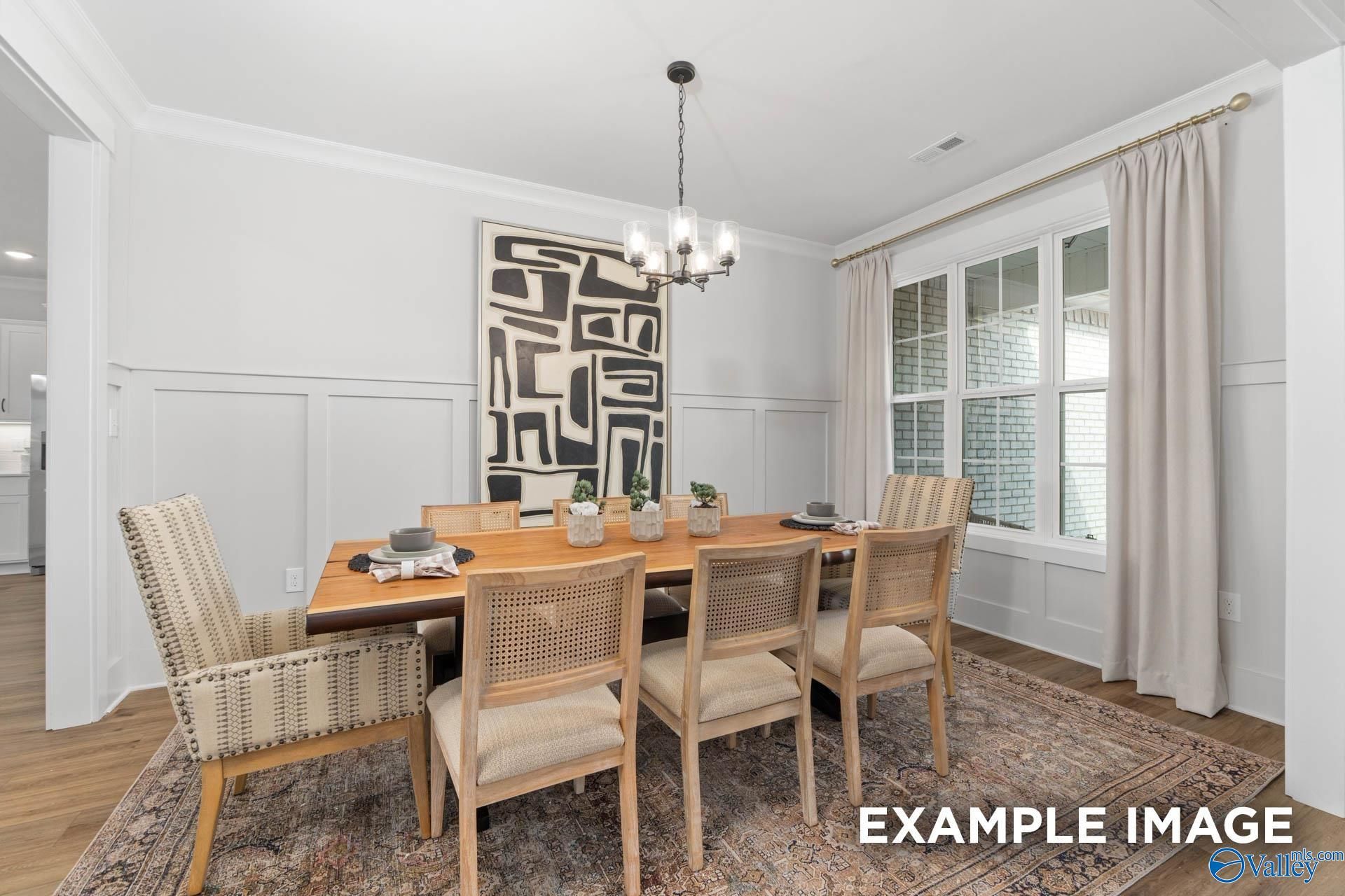 Elegant formal dining room with wooden table, upholstered chairs, chandelier, and abstract art in The Finleigh home, Decatur, Alabama