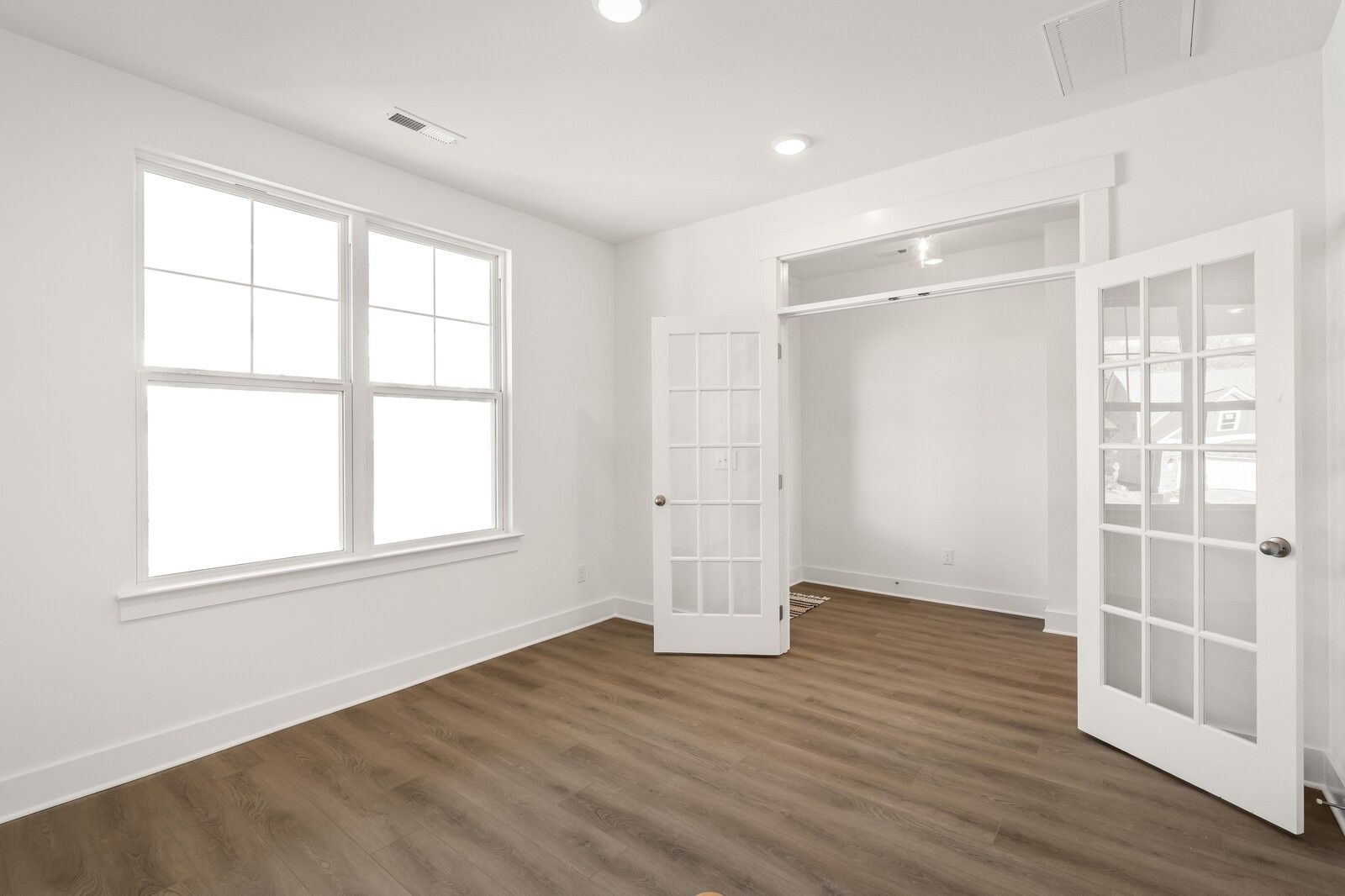 Bright master bedroom featuring open French doors to walk-in closet, hardwood floors in Davidson Homes The Ash A, Gallatin, TN