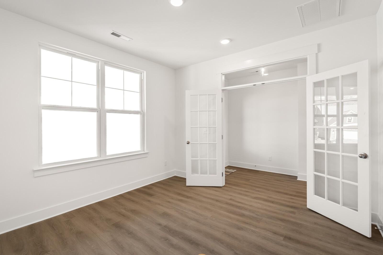 Bright master bedroom featuring open French doors to walk-in closet, hardwood floors in Davidson Homes The Ash A, Gallatin, TN