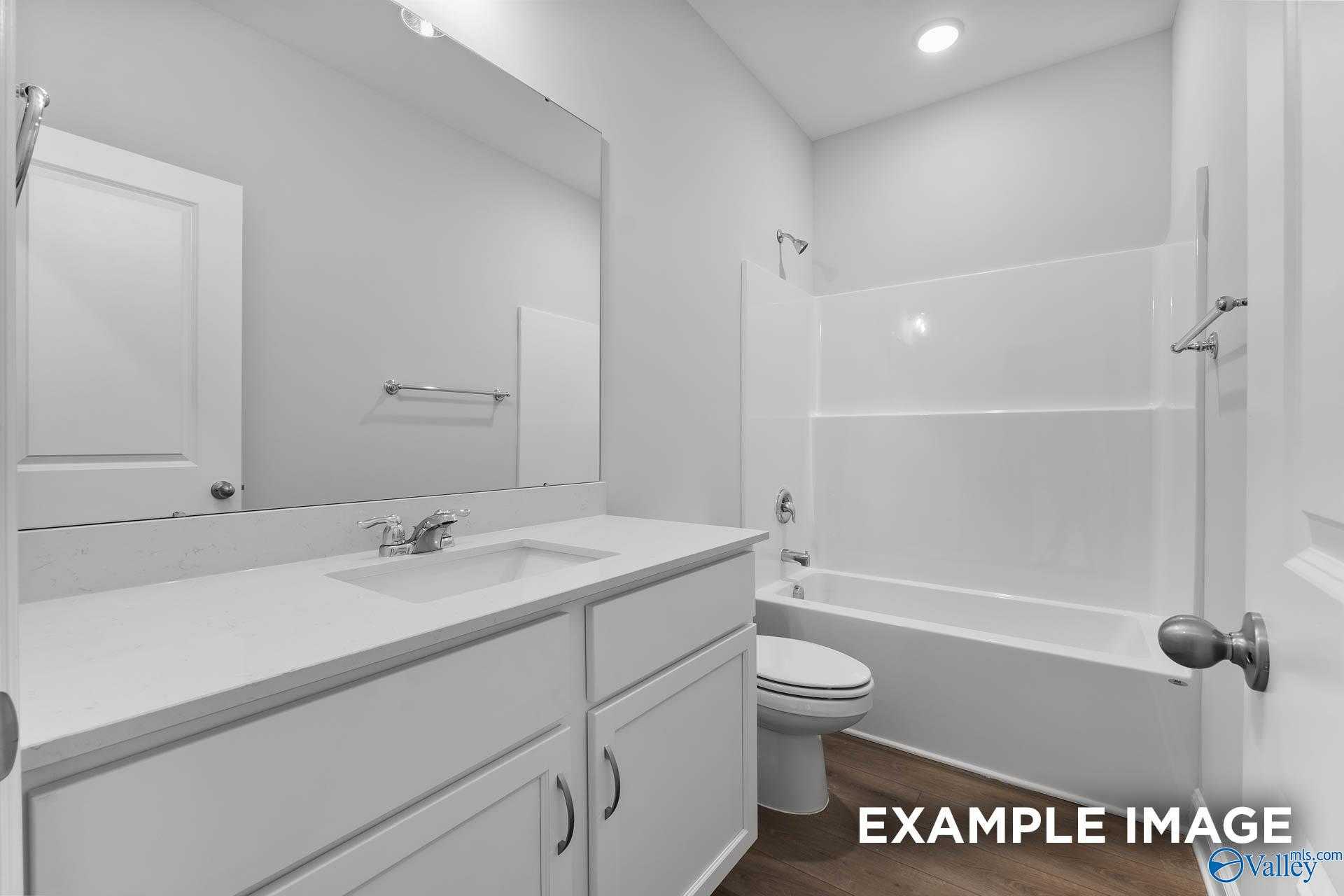 Bright white secondary bathroom with double vanity, bathtub-shower combo, and toilet in Davidson Homes The Asheville V, Athens, Alabama