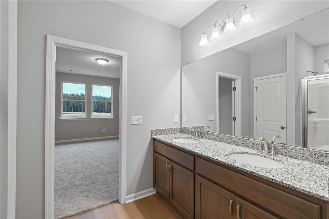 Elegant master bathroom with double granite vanity, dual sinks, frameless shower in Davidson Homes The Luna B, Opelika, Alabama