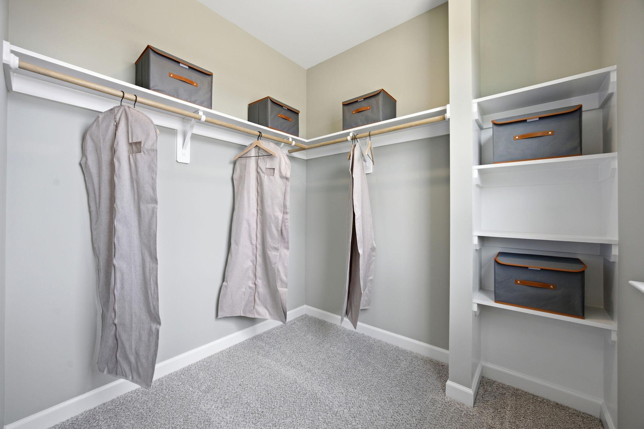 Spacious walk-in closet in The Burke C master suite featuring built-in shelving, hanging rods, and storage bins.