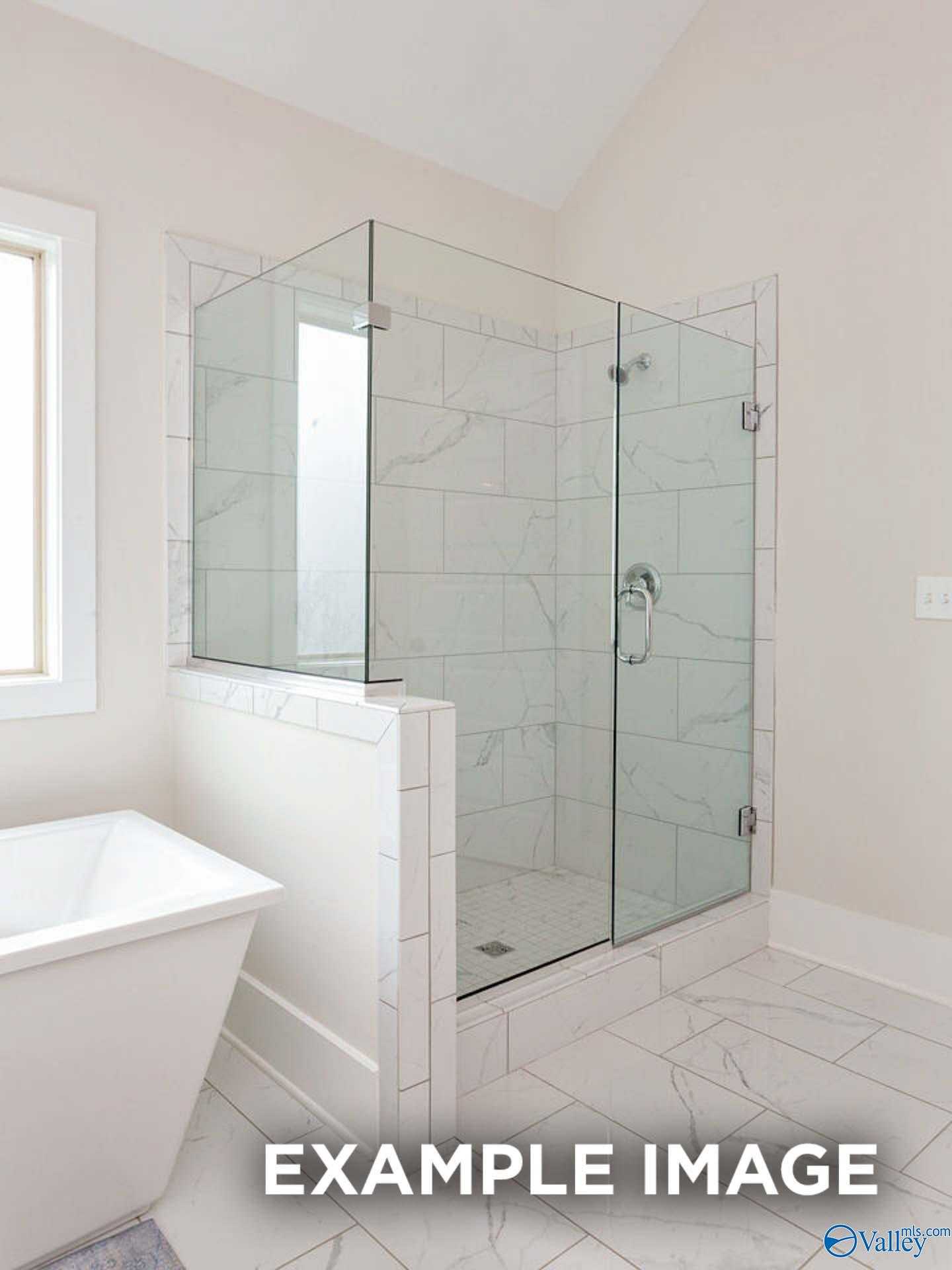 Modern master bathroom featuring frameless glass shower and freestanding tub in Davidson Homes The Finleigh, Meridianville, Alabama