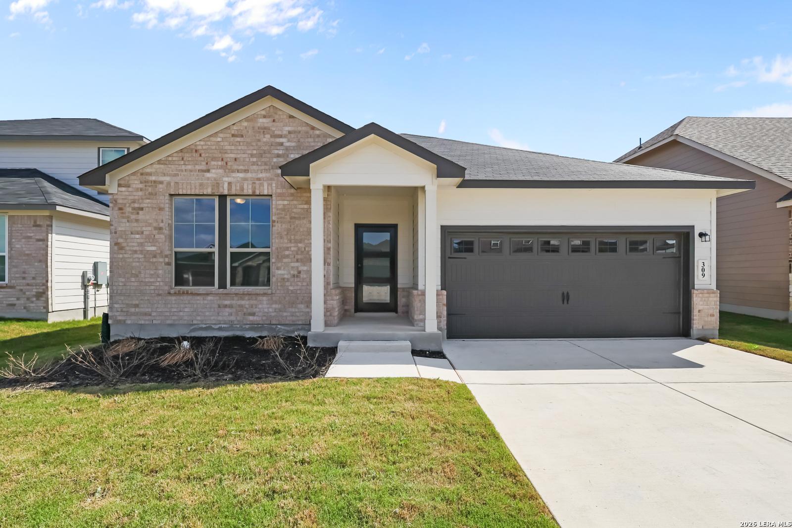 Modern 1-story brick home with 2-car garage, covered porch, and lush front yard in Hannah Heights, Seguin, Texas – Davidson Homes The Daphne H