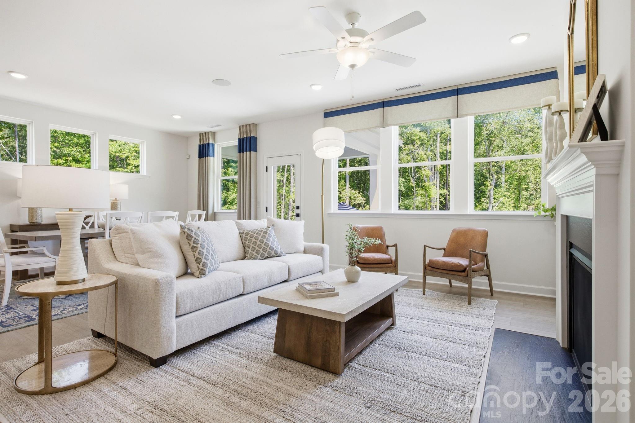 Bright open living room with fireplace and dining area in Davidson Homes The Ashport G floor plan in Windgate, Mooresville.