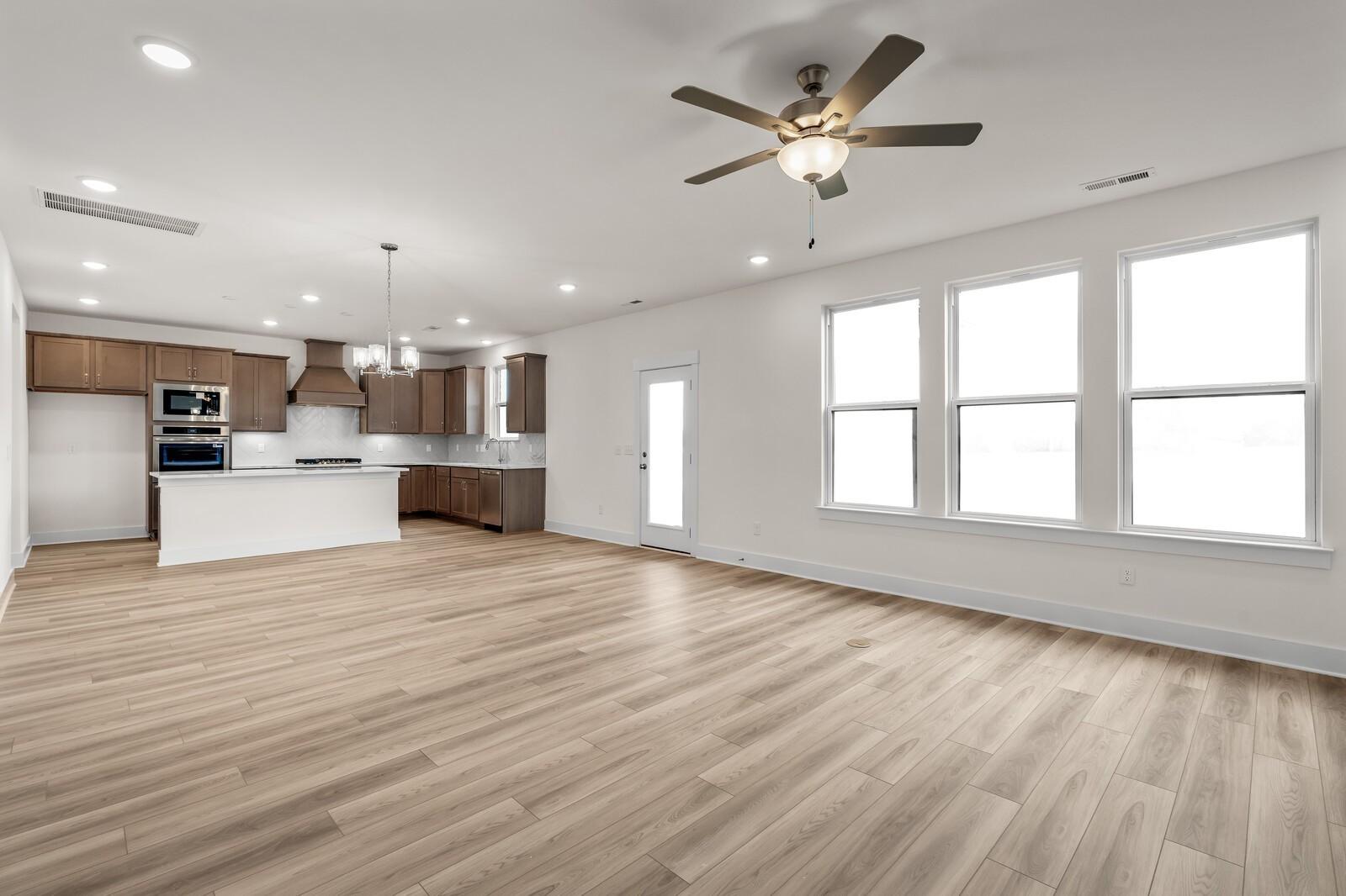 Open-concept kitchen and living area with wood floors in The Henry C floor plan at Benders Cove, Mt. Juliet, Tennessee.