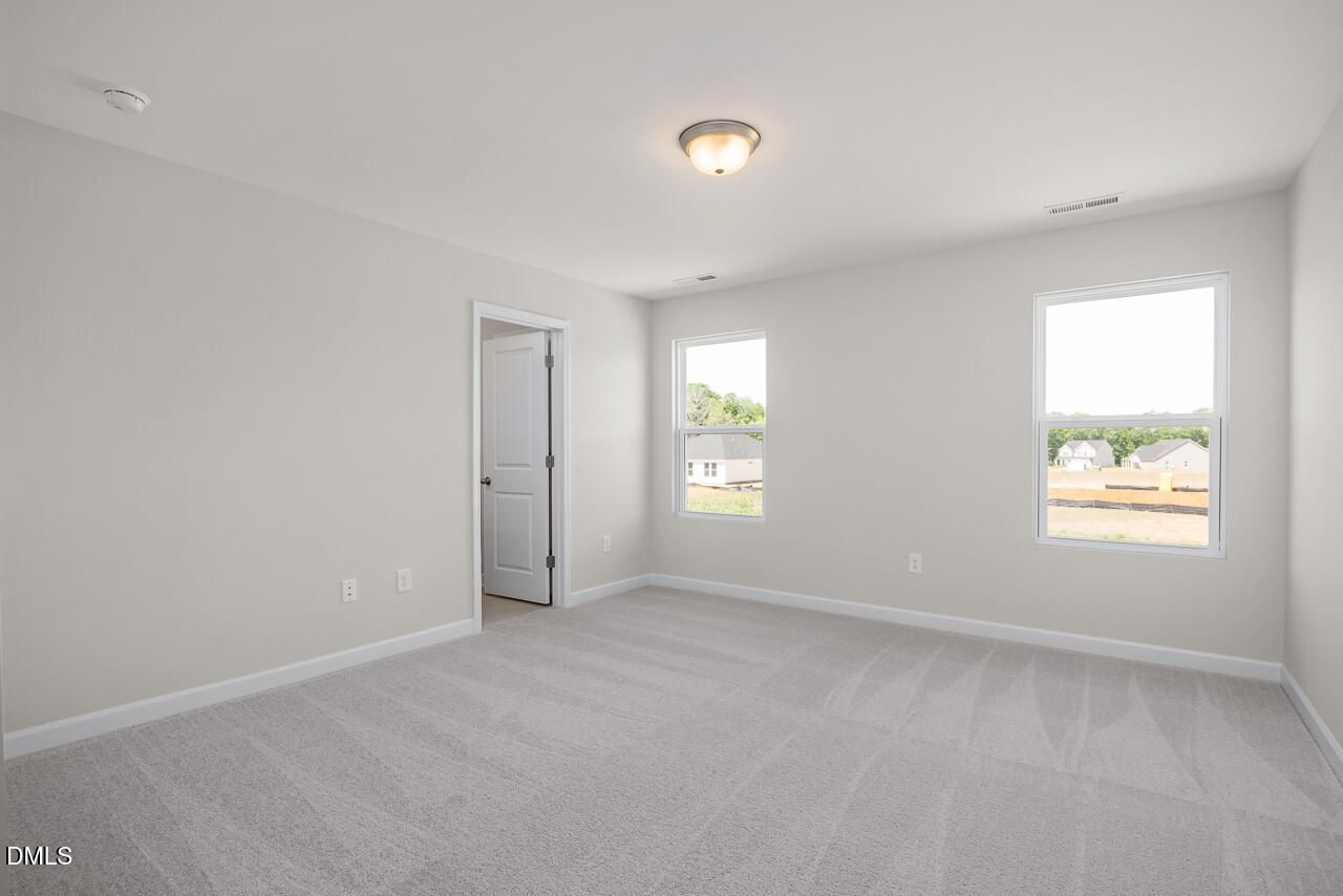 Bright, spacious secondary bedroom with neutral carpet in The Grace C floor plan at Retreat at North Main, Lillington, NC.