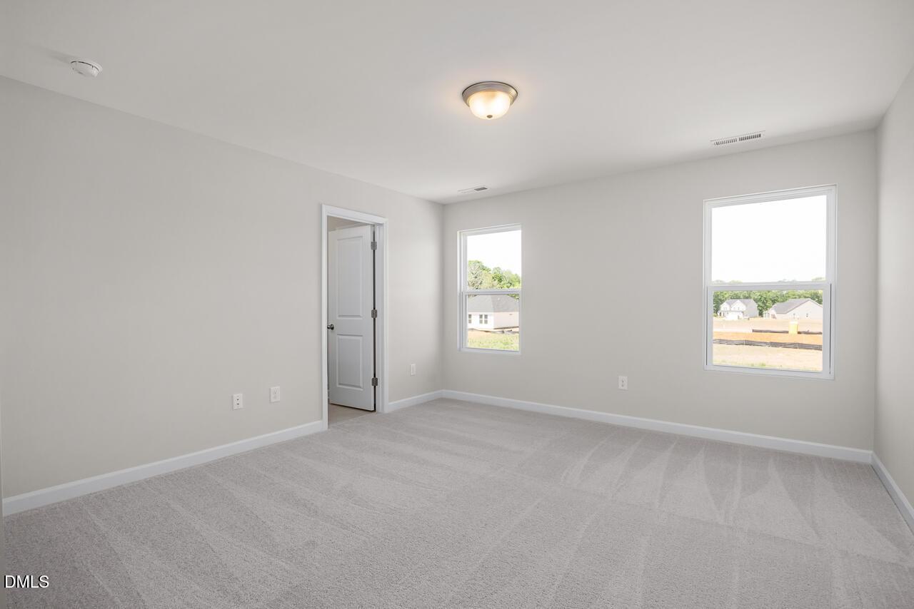 Bright, spacious secondary bedroom with neutral carpet in The Grace C floor plan at Retreat at North Main, Lillington, NC.
