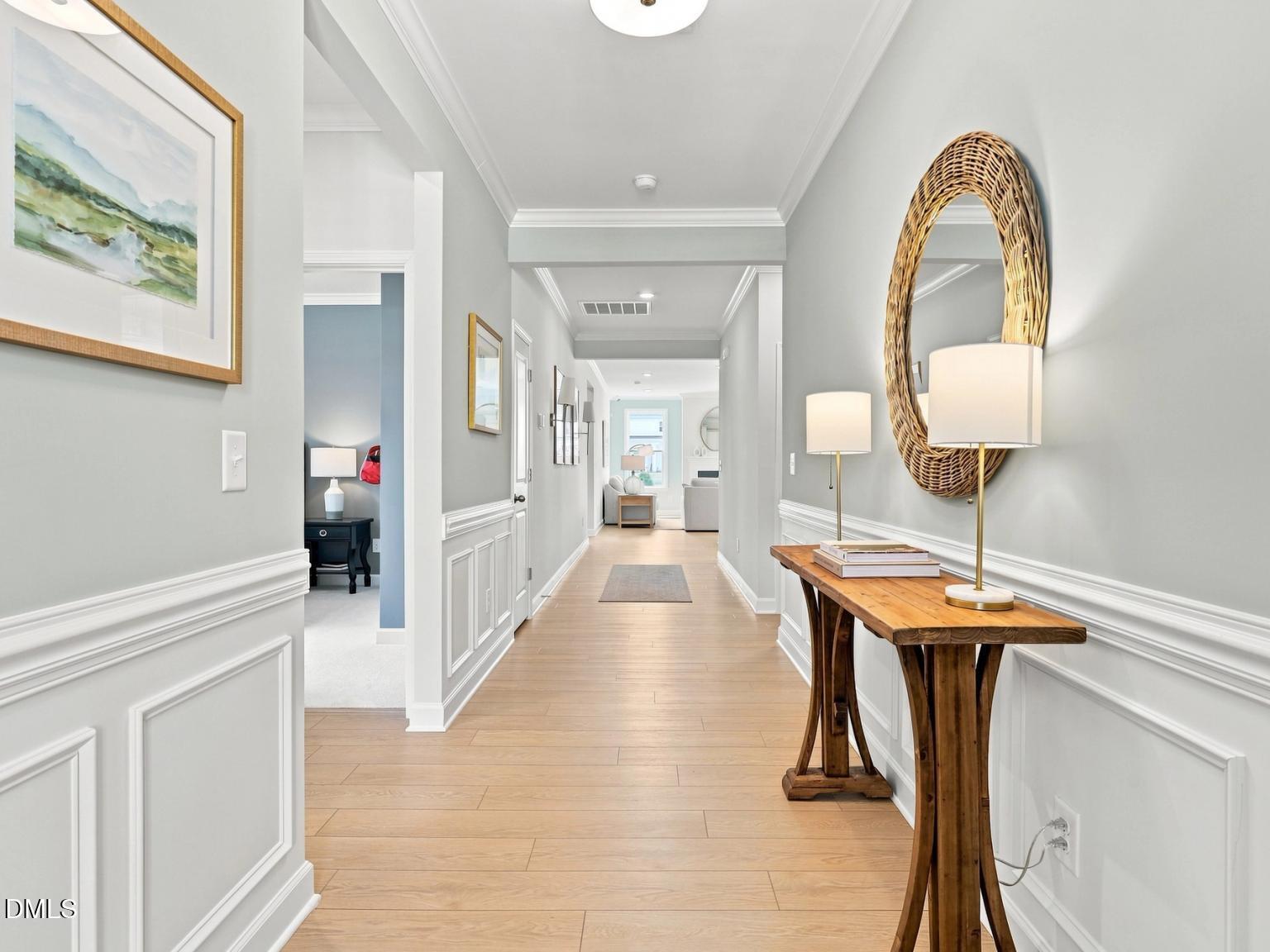 Bright hallway with wainscoting and wood-look flooring in The Daphne C floor plan at Woodland Crossing in Zebulon, NC.