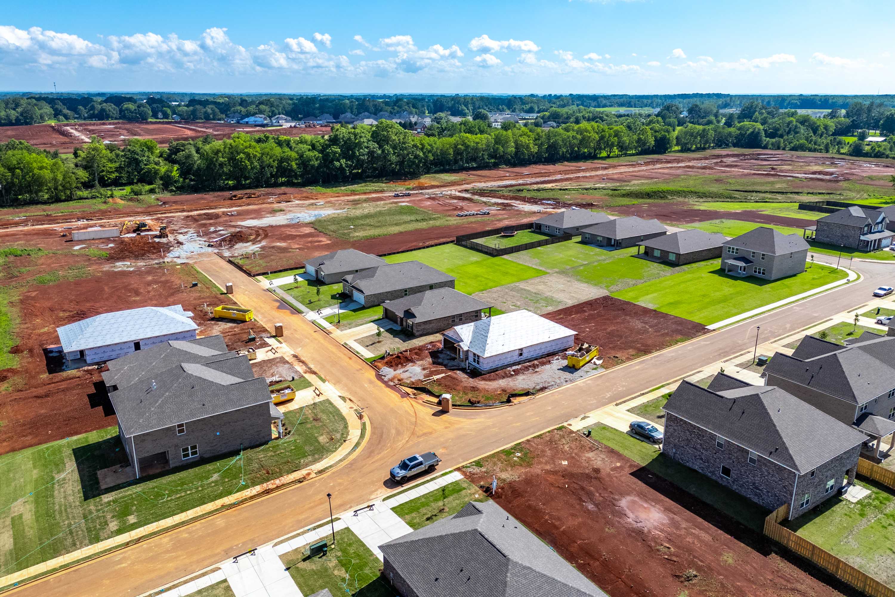 Aerial view of new homes and construction sites at The Meadows in Athens Alabama by Davidson Homes amid wooded surroundings