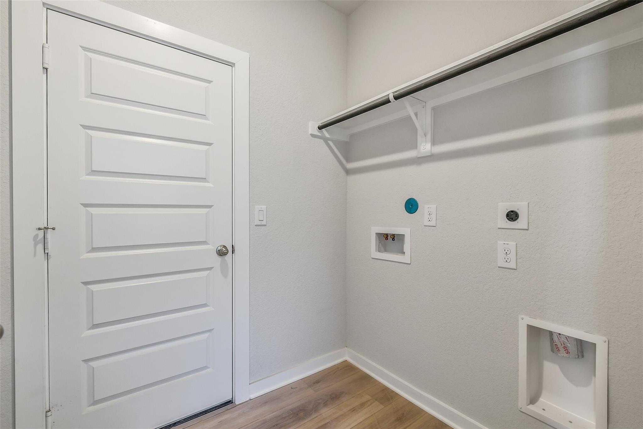 Functional laundry room with built-in shelves, washer-dryer hookups, and gray walls in Davidson Homes The Rio Grande H, Magnolia Texas