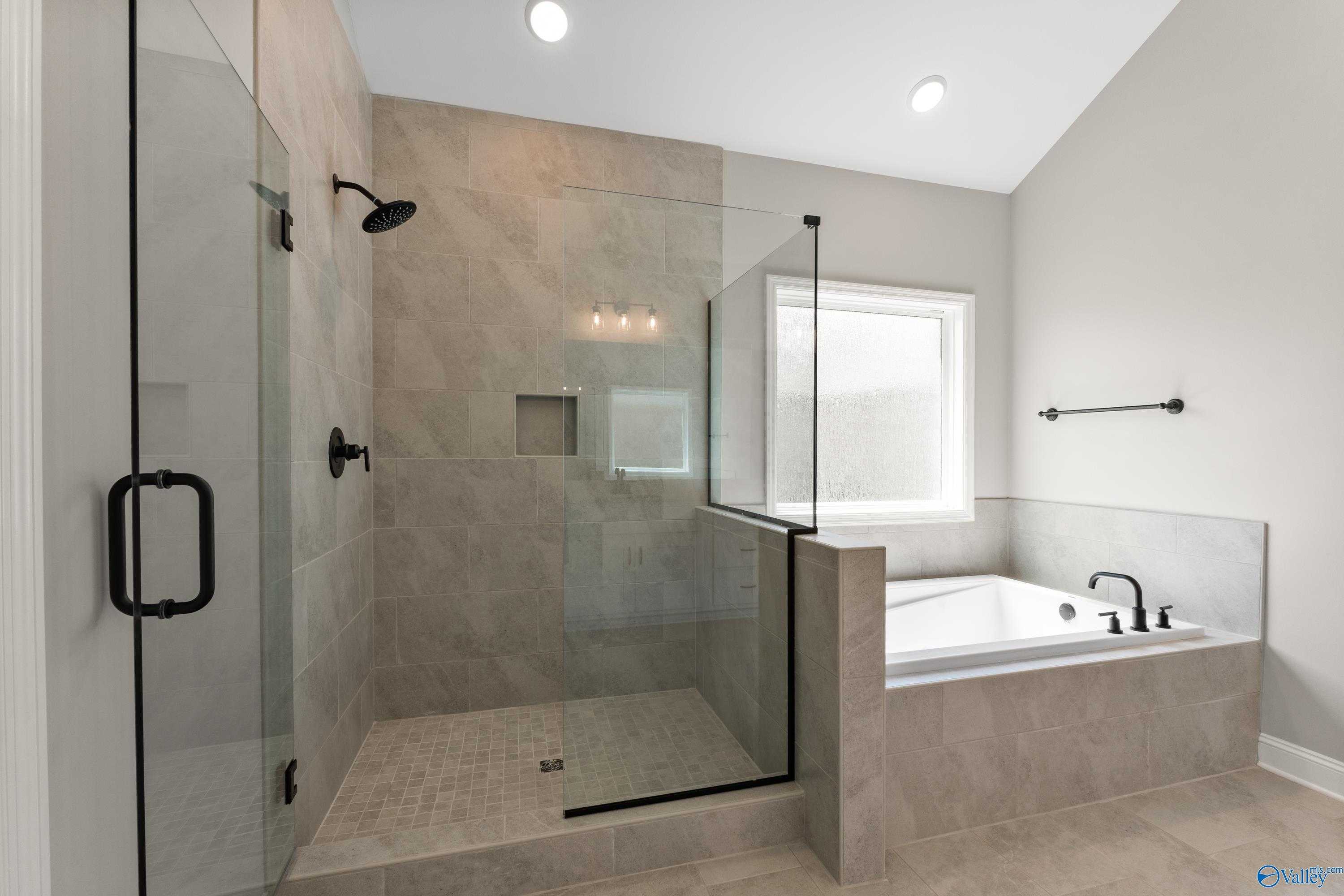 Modern master bathroom featuring glass walk-in shower and soaking tub in Davidson Homes The Finleigh, Toney, Alabama