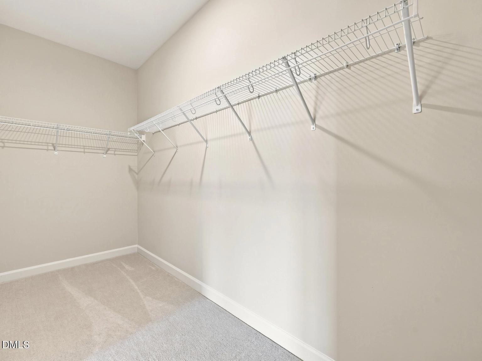 Walk-in closet with white wire shelving in The Daphne C floor plan by Davidson Homes at Woodland Crossing in Zebulon, NC.
