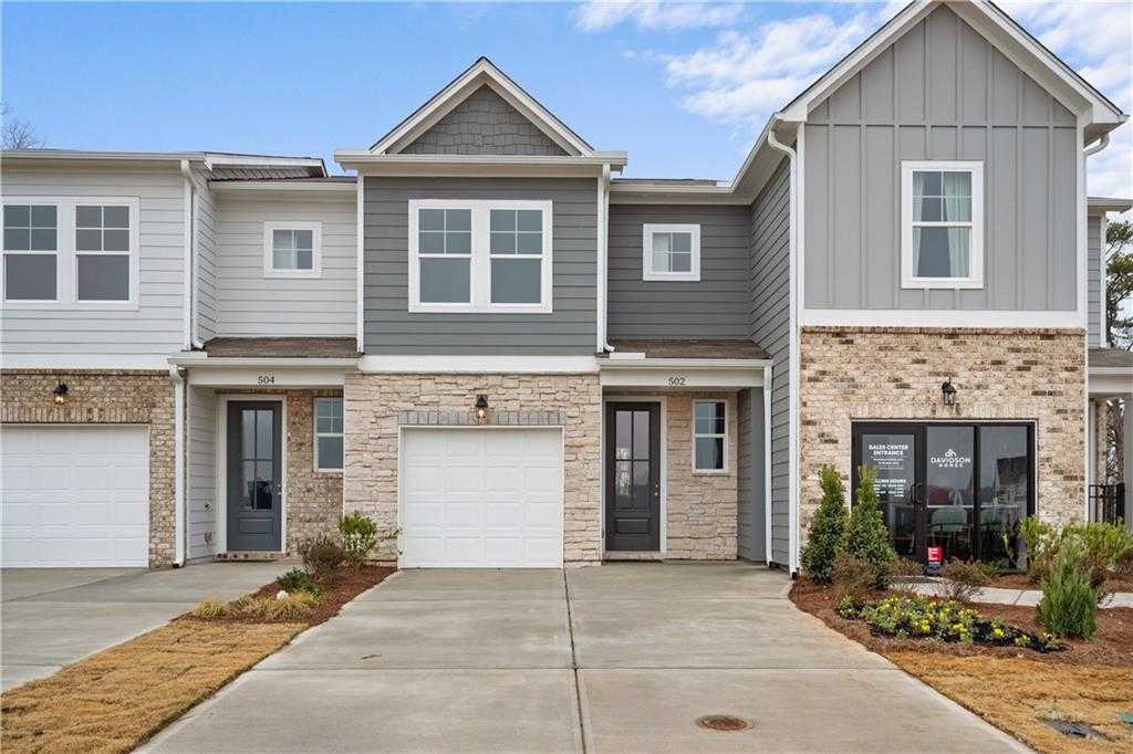 Modern 2-story townhomes with gray siding, brick bases, and 1-car garages in Stegall Village, Emerson, Georgia