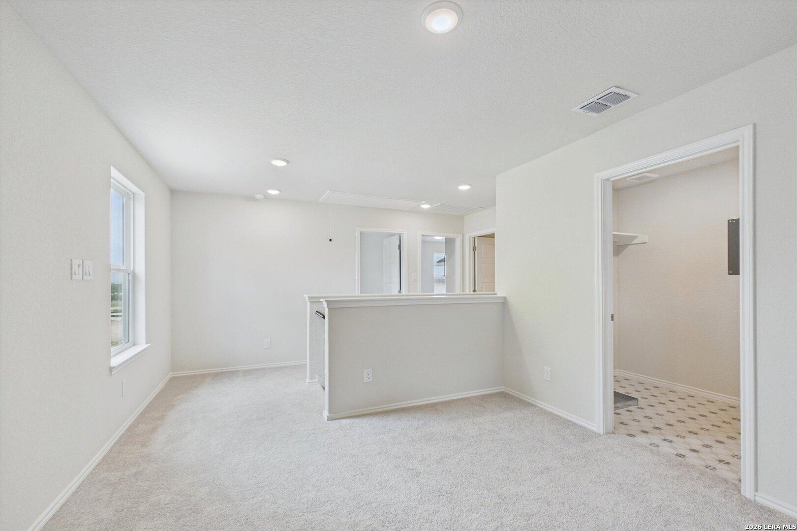 Spacious carpeted upstairs loft in The Charlotte B floor plan at Meadows at Oak Creek, San Antonio, Texas.