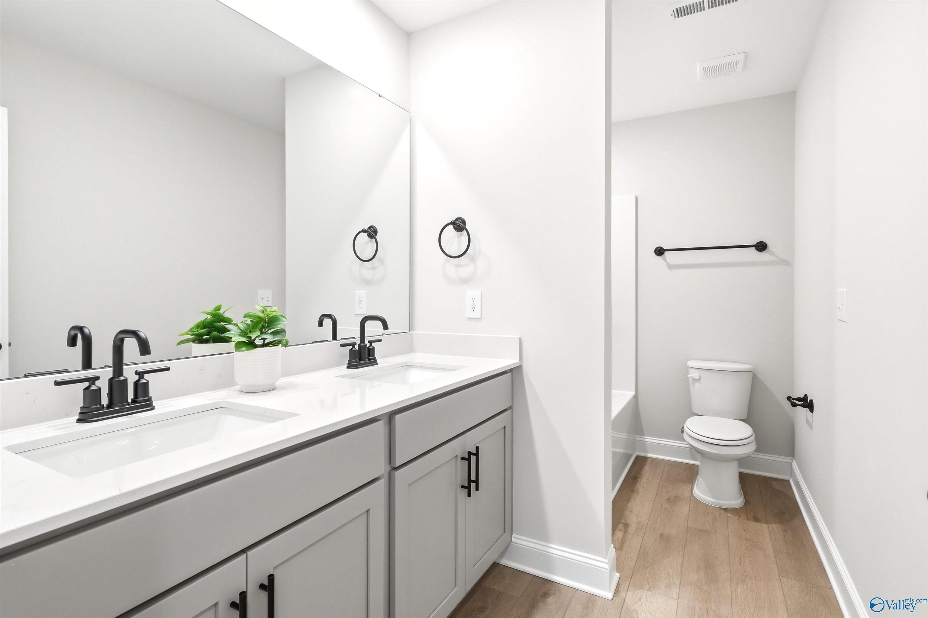 Double vanity bathroom with gray cabinets, matte black faucets, and white quartz countertop in Davidson Homes The Russell A, Huntsville