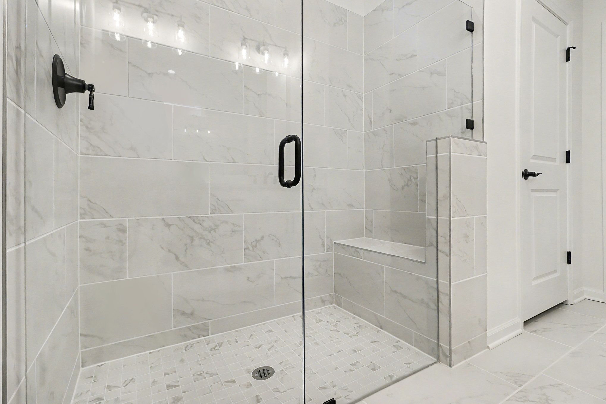 Modern master bathroom with double vanity, frameless glass shower, and wood flooring in Davidson Homes The Daphne B, Loganville GA