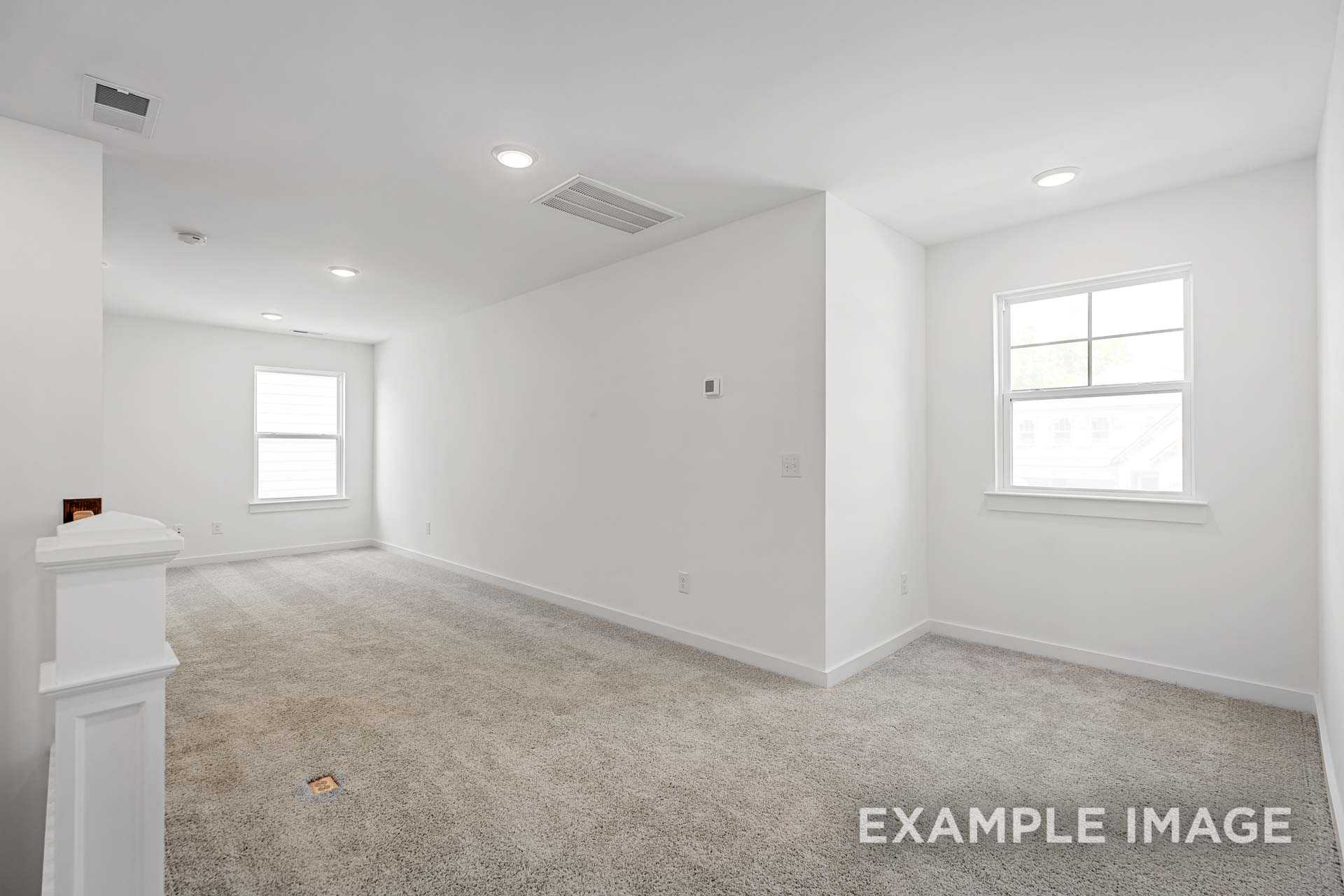 Spacious empty upstairs bedroom in The Ash C with white walls, beige carpet, large windows, and recessed lighting