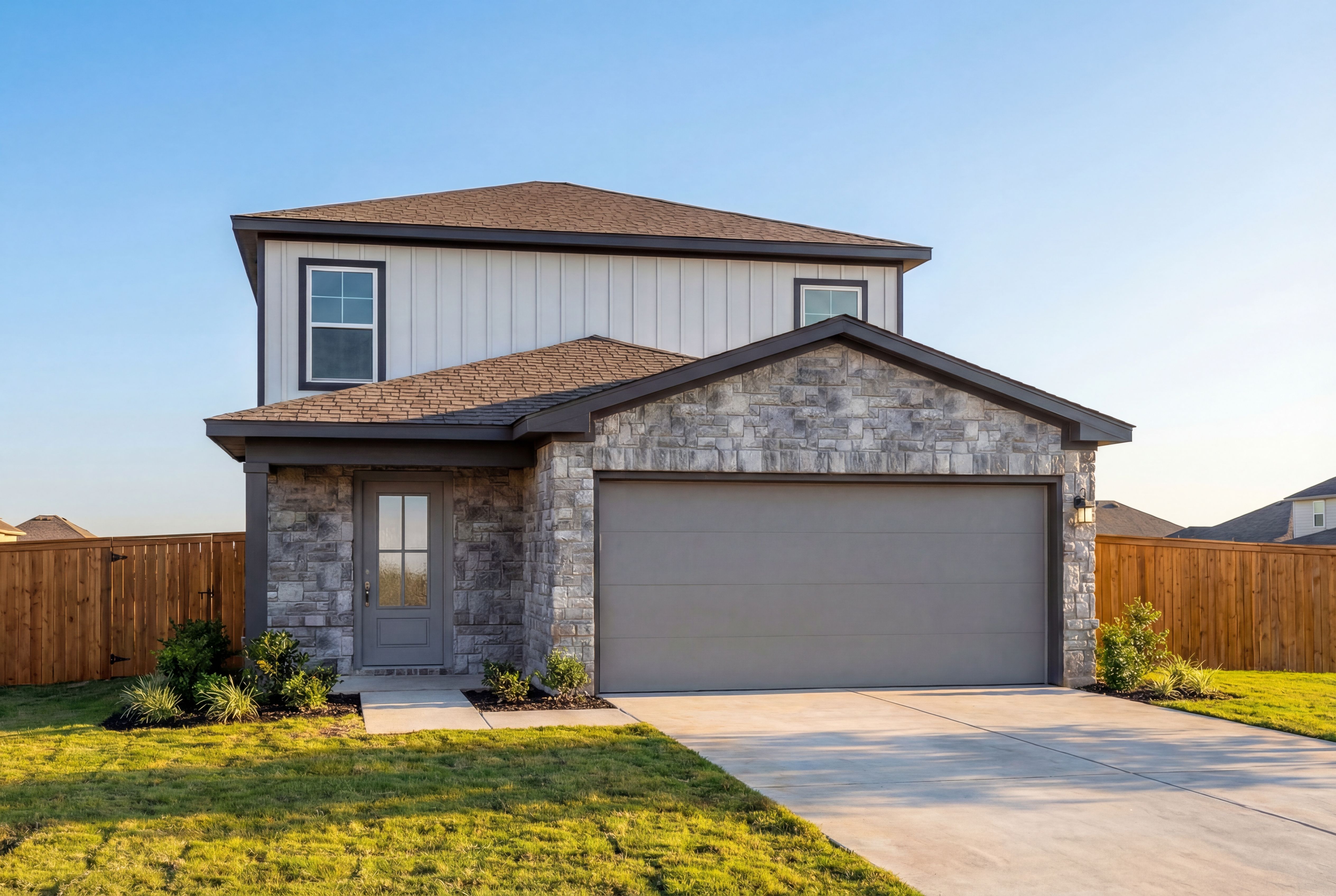 Two-story The Sabine C elevation featuring stone accents, white siding, two-car garage, and landscaped front yard