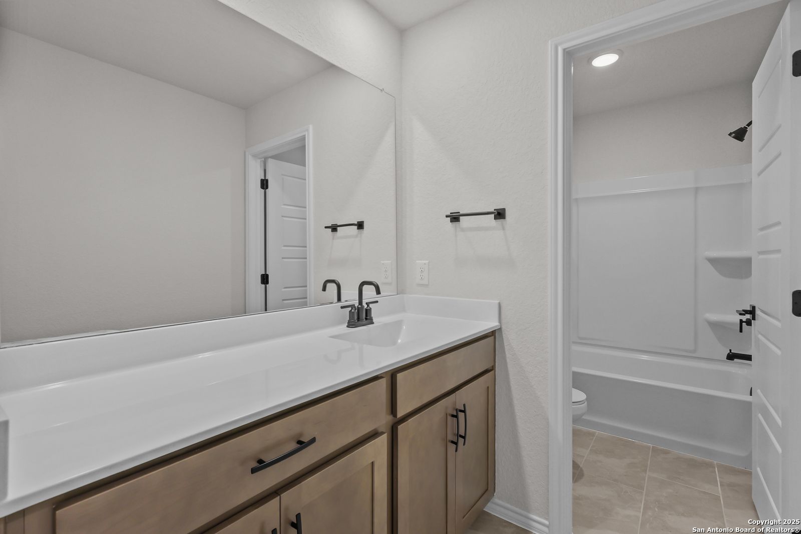 Modern double vanity with white quartz countertop and shaker cabinets in secondary bathroom, Davidson Homes The Florence C, San Antonio
