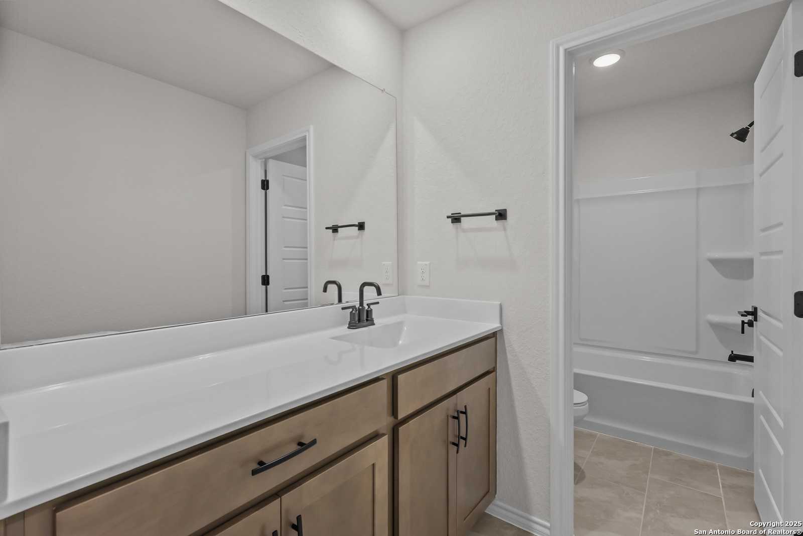 Modern double vanity with white quartz countertop and shaker cabinets in secondary bathroom, Davidson Homes The Florence C, San Antonio