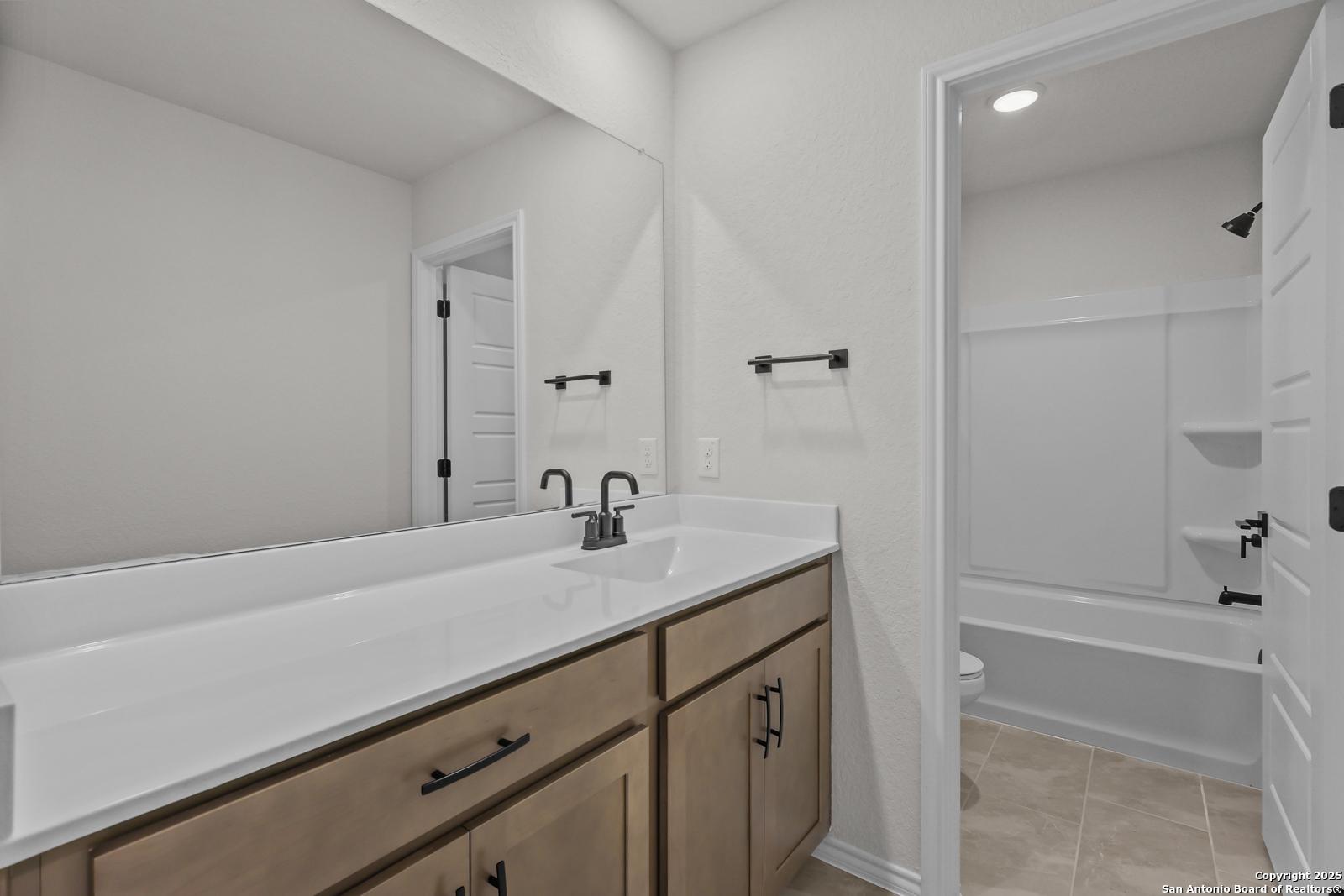 Modern double vanity with white quartz countertop and shaker cabinets in secondary bathroom, Davidson Homes The Florence C, San Antonio