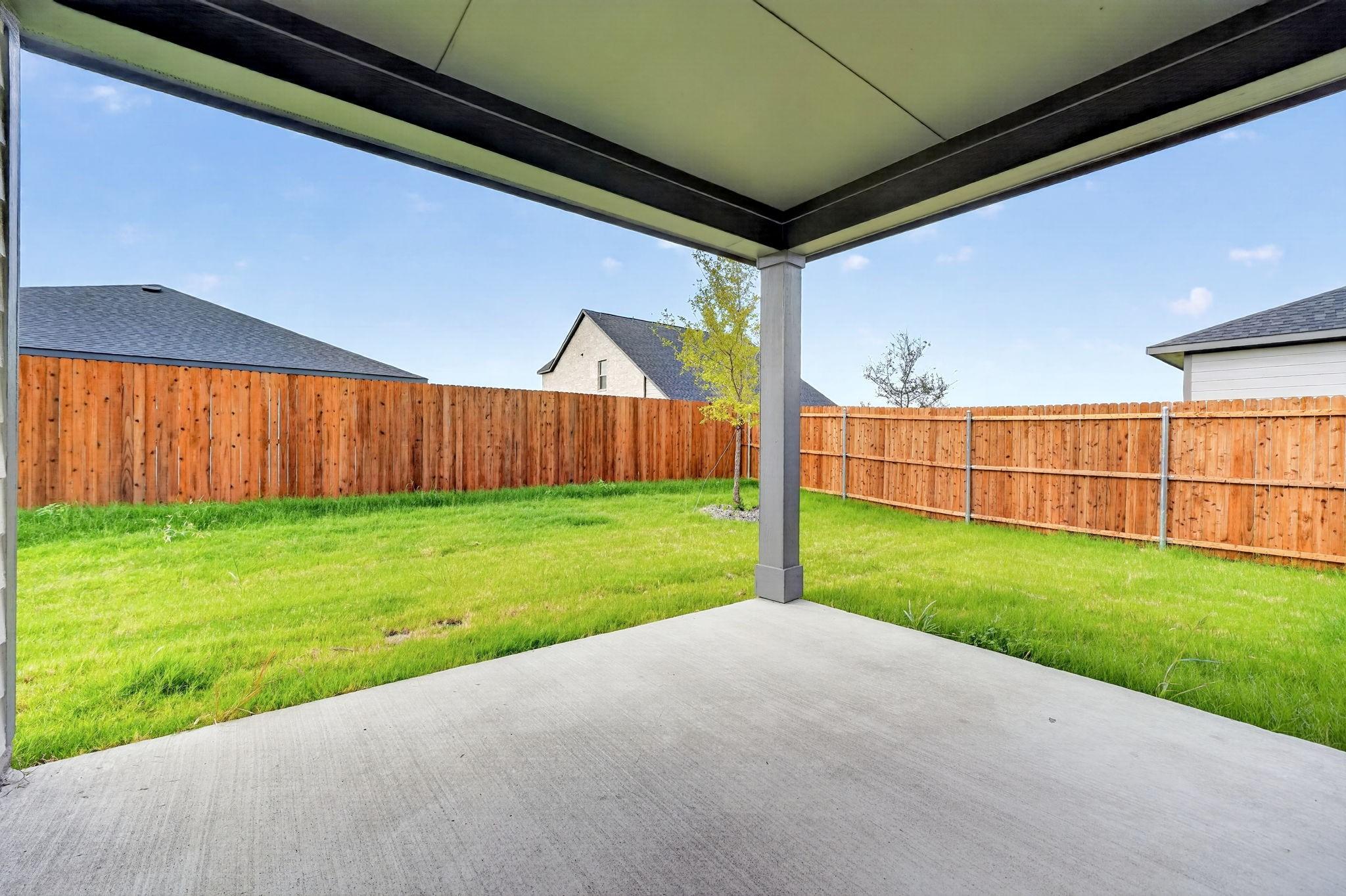 Covered patio with concrete slab overlooking fenced backyard in Davidson Homes The Holly F, Meadow Ridge Estates, Josephine, Texas