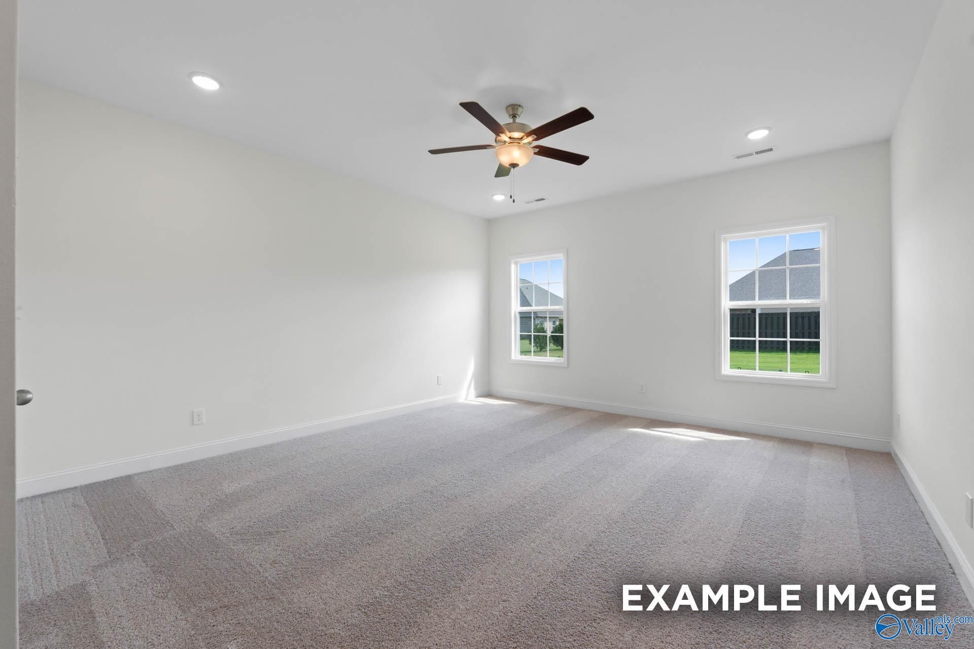 Spacious, carpeted bedroom with ceiling fan and natural light in The Rockford B floor plan, Kendall Downs, Toney, AL.