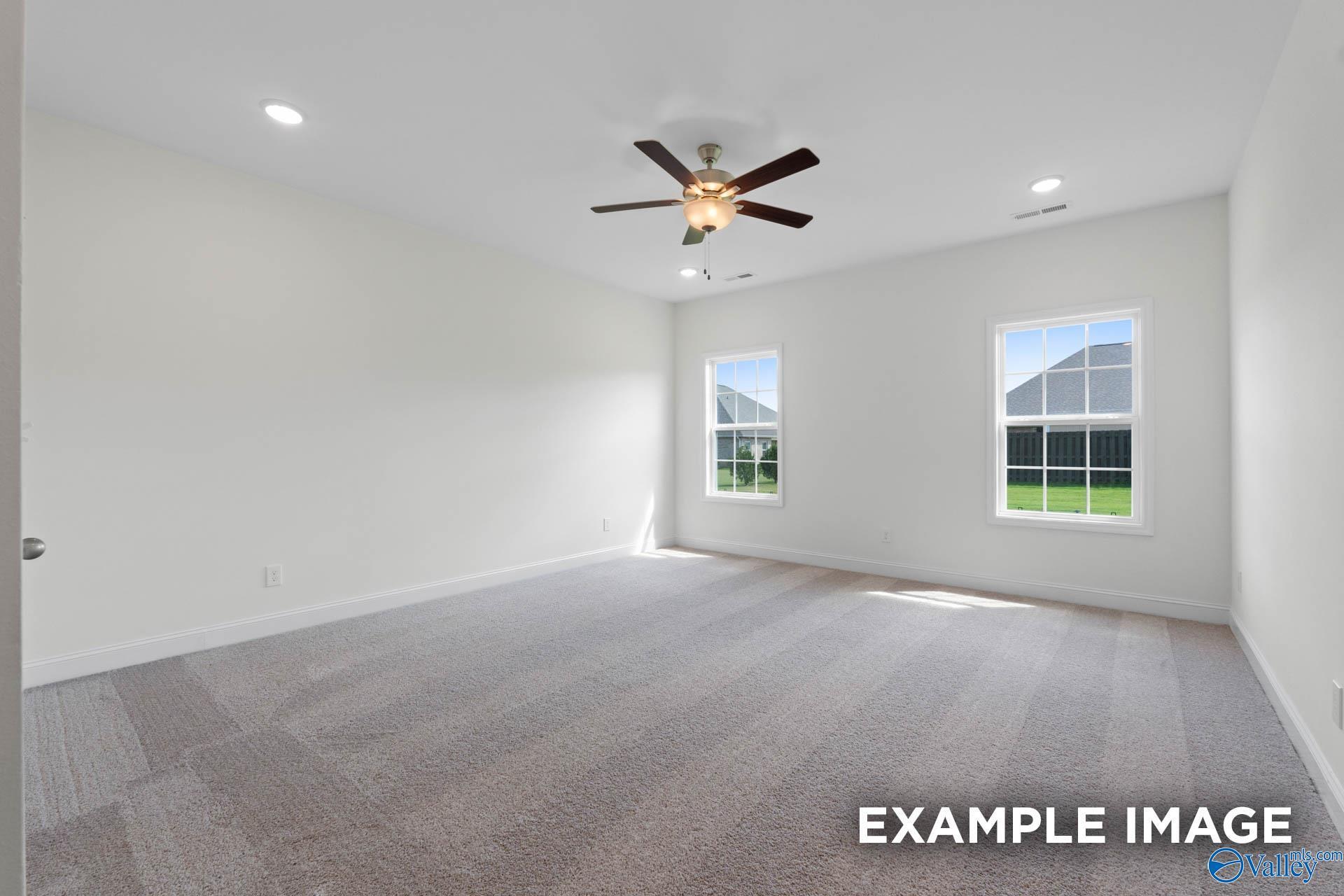 Spacious, carpeted bedroom with ceiling fan and natural light in The Rockford B floor plan, Kendall Downs, Toney, AL.