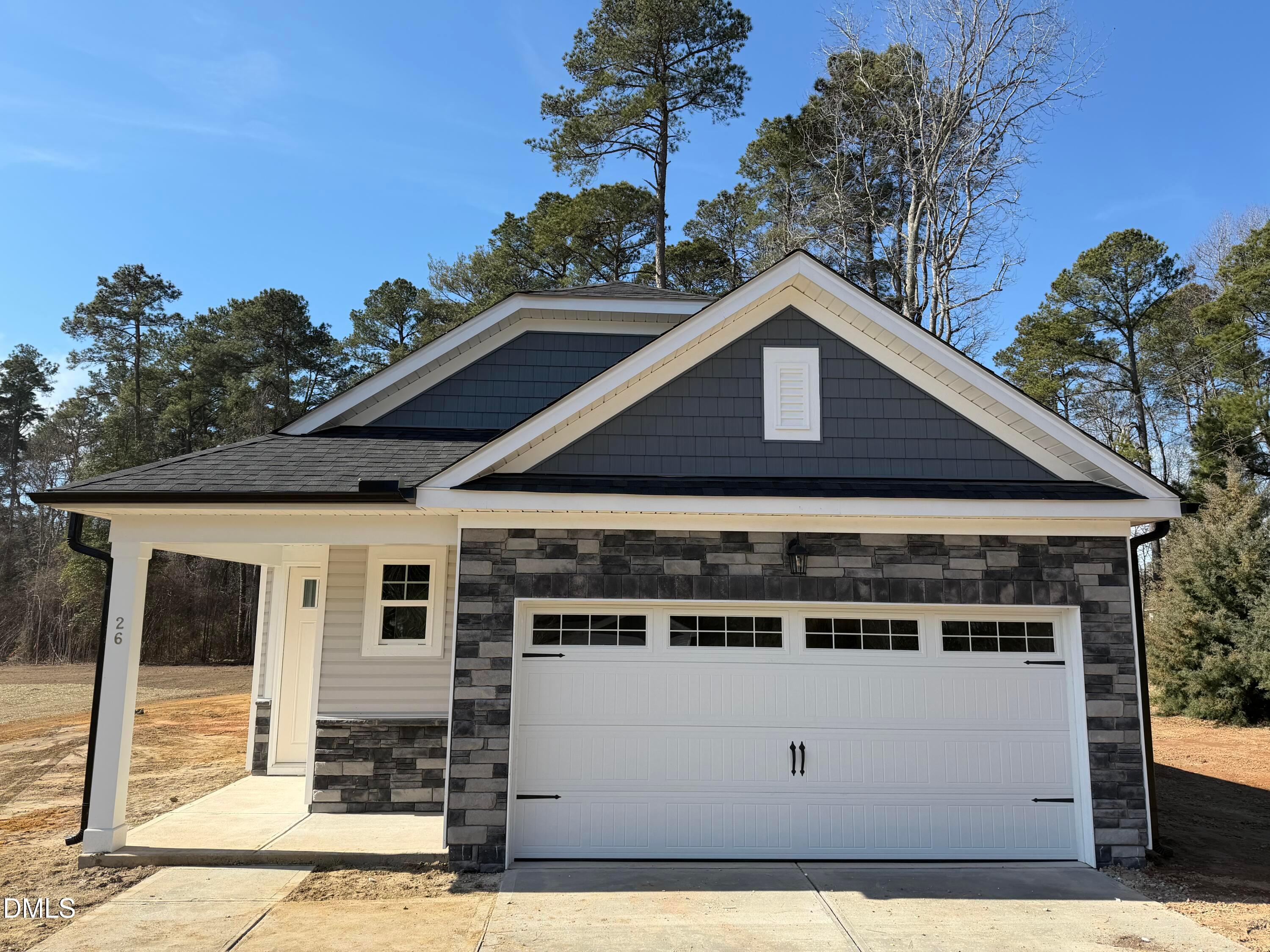 Modern single-story 3-bedroom home with 2-car garage, stone accents, and front porch in Wellers Knoll, Lillington, North Carolina