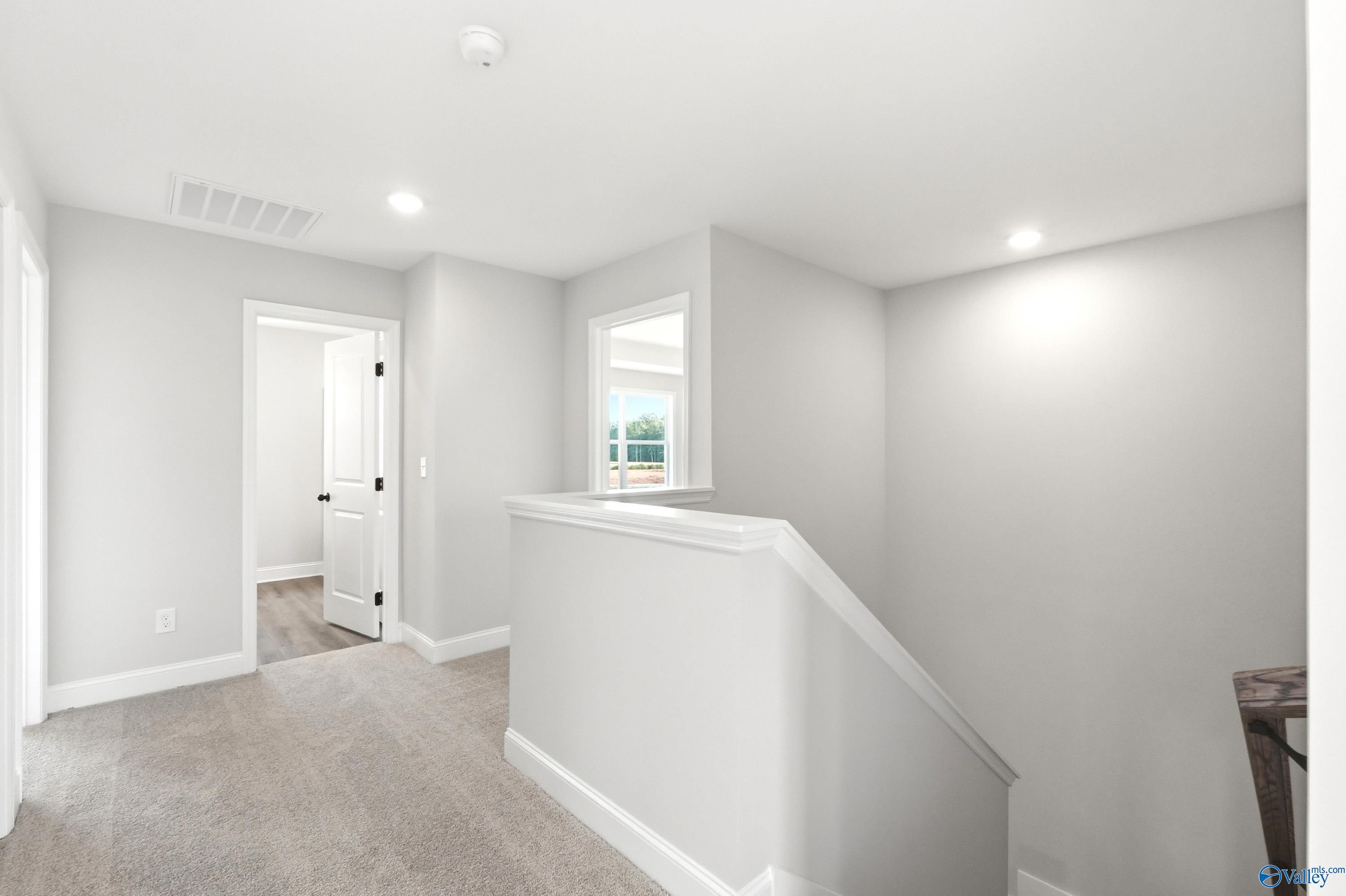 Bright second-floor landing with neutral carpet in The Shelby A floor plan at Clearview in Hazel Green, Alabama.