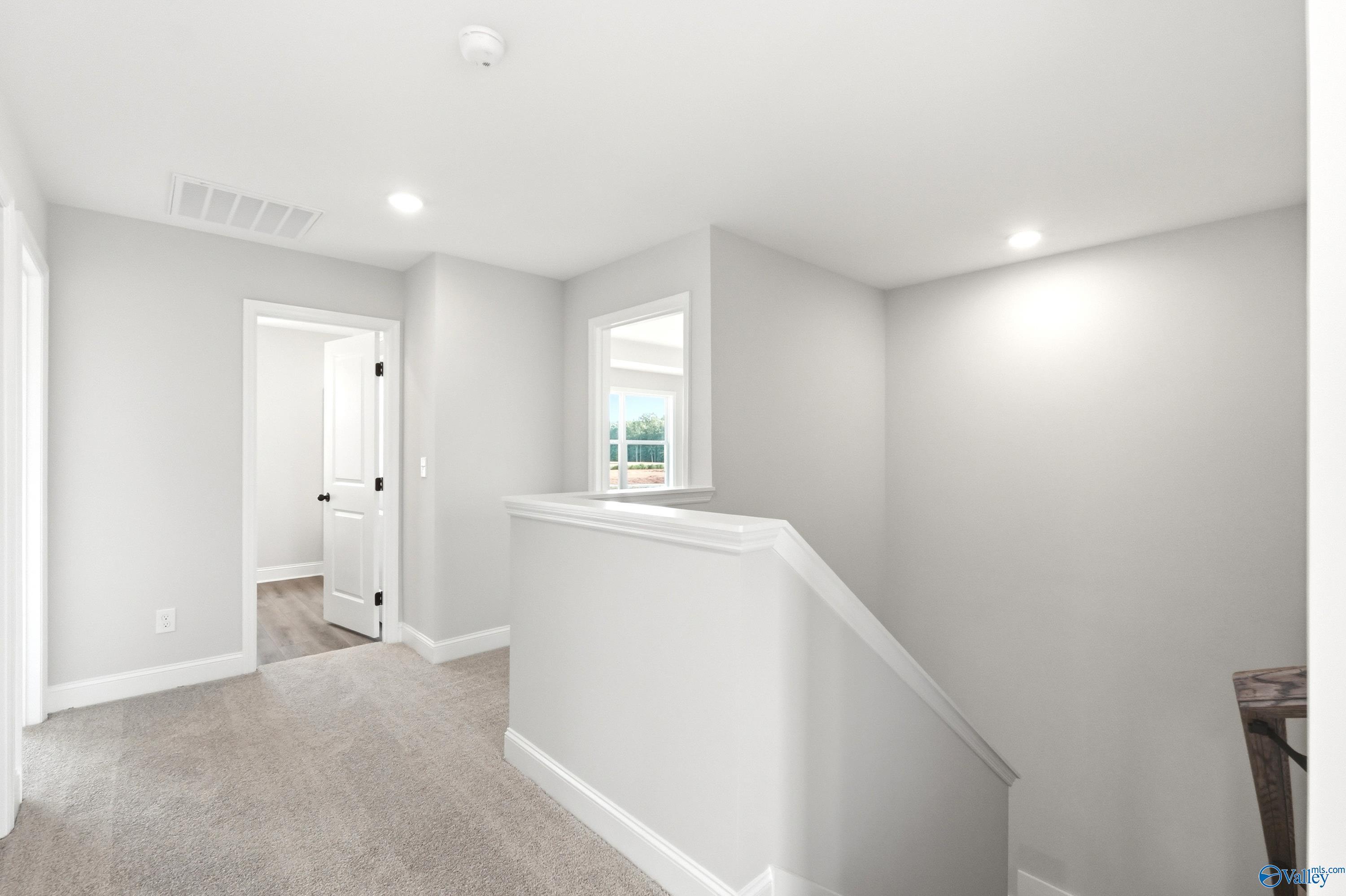 Bright second-floor landing with neutral carpet in The Shelby A floor plan at Clearview in Hazel Green, Alabama.