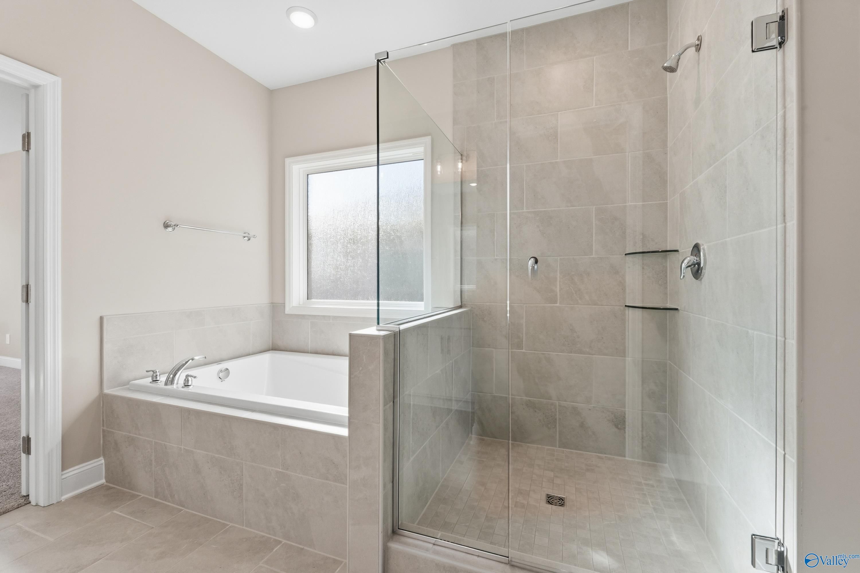 Luxurious master bathroom with soaking tub and glass walk-in shower in Davidson Homes The Rockford, Harvest, Alabama