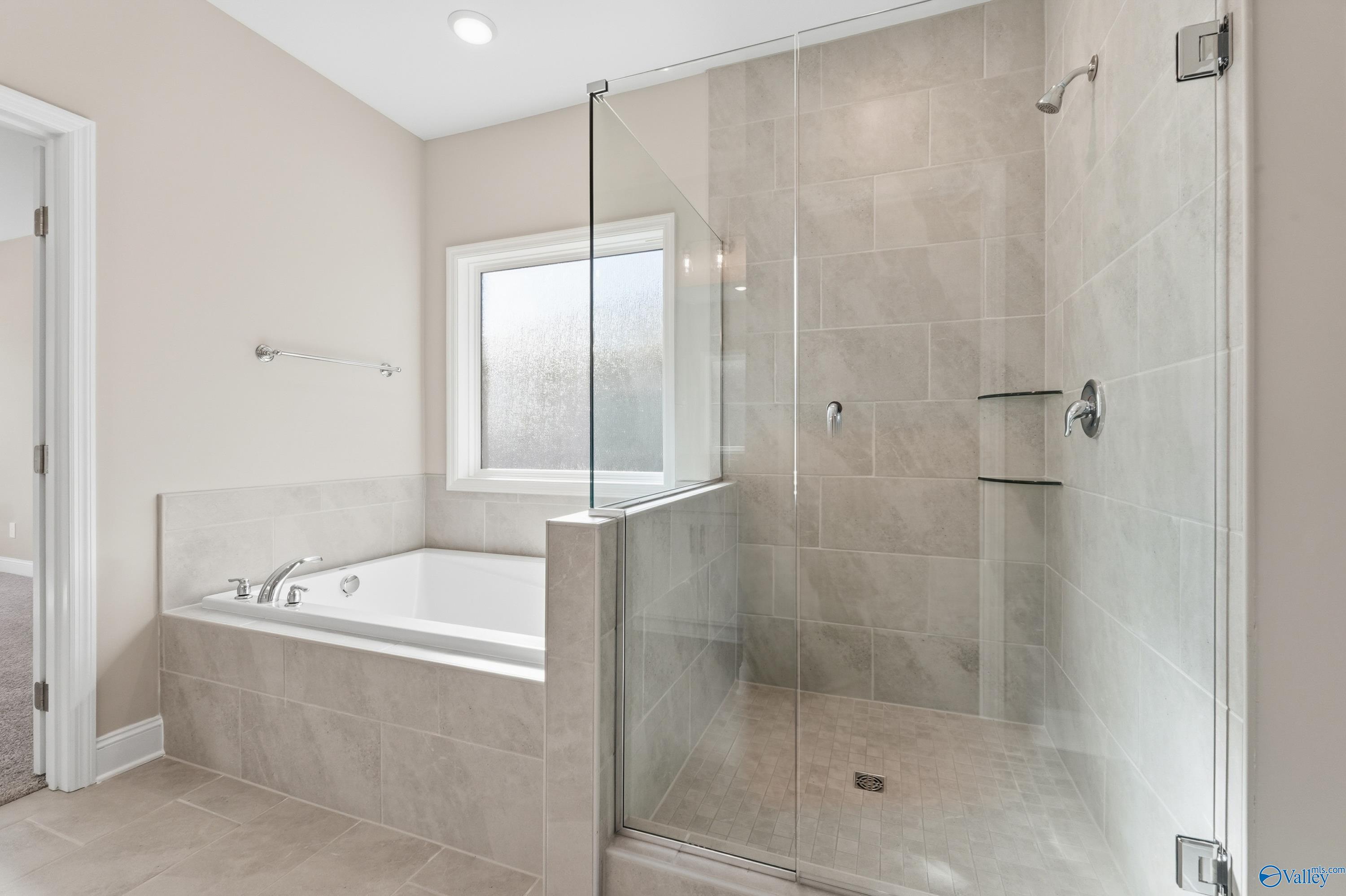 Luxurious master bathroom with soaking tub and glass walk-in shower in Davidson Homes The Rockford, Harvest, Alabama