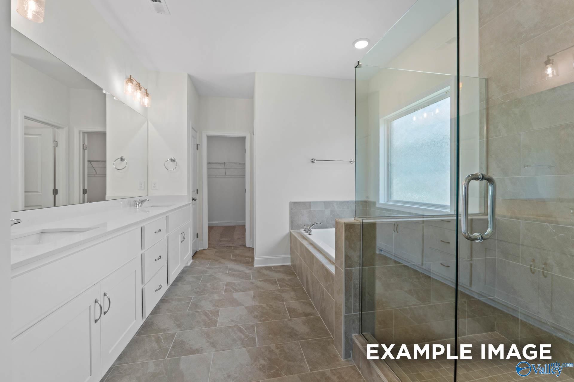 Elegant master bathroom with double vanity, freestanding tub, and glass shower in Davidson Homes The Oxford, Huntsville, Alabama