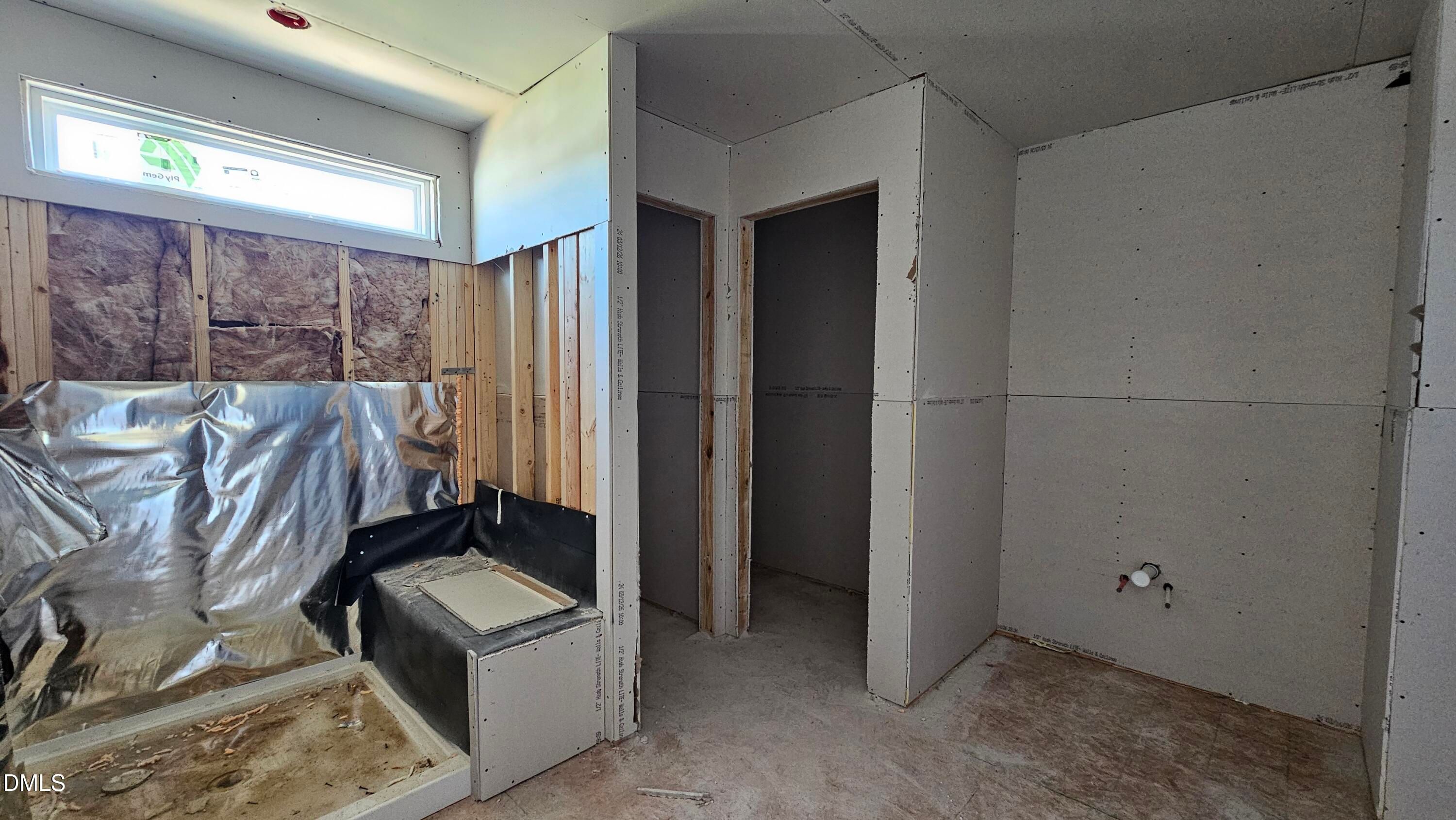 Unfinished bathroom construction in The Graham floor plan at Springvale, Fuquay-Varina, featuring a walk-in shower frame.