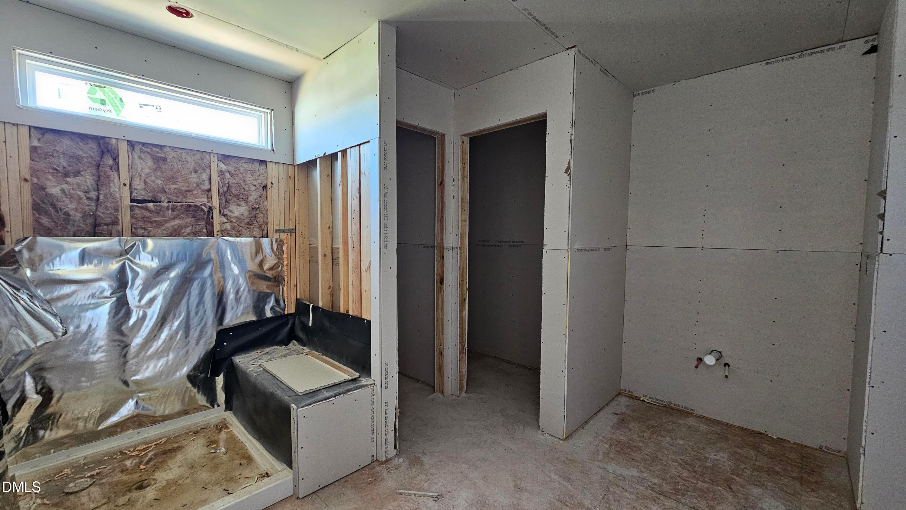 Unfinished bathroom construction in The Graham floor plan at Springvale, Fuquay-Varina, featuring a walk-in shower frame.