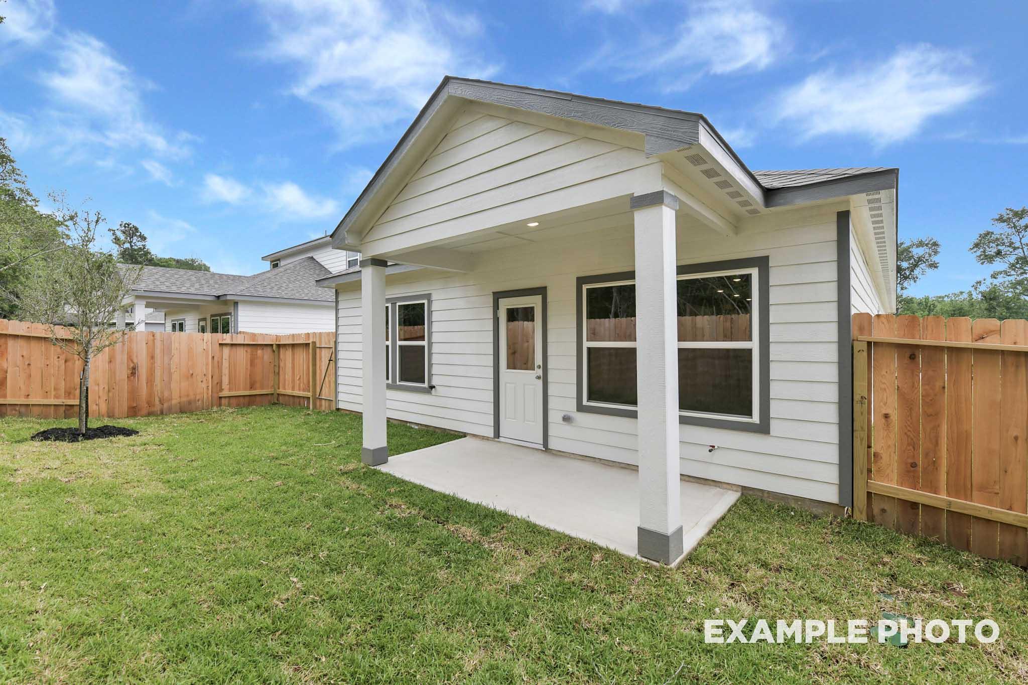 Covered back patio of The Frio floor plan by Davidson Homes featuring a spacious backyard and wood privacy fencing.