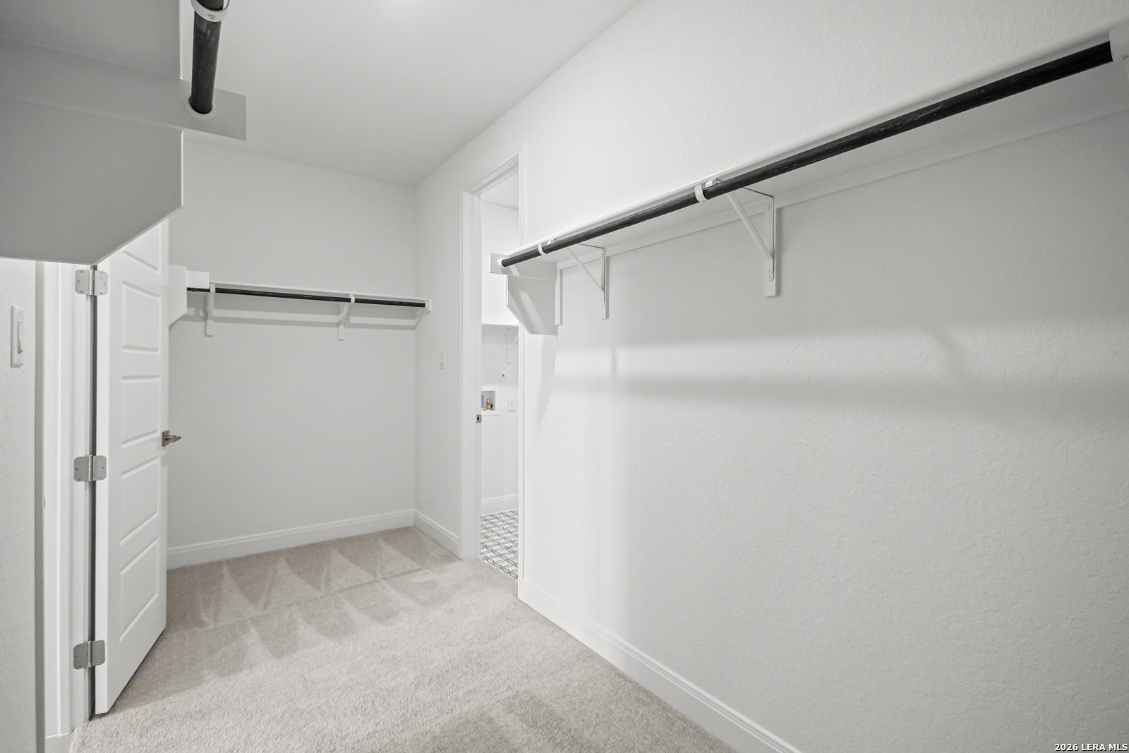 Spacious walk-in closet with shelving in The Lanier G floor plan at The Reserve at Potranco Oaks, Castroville, Texas.