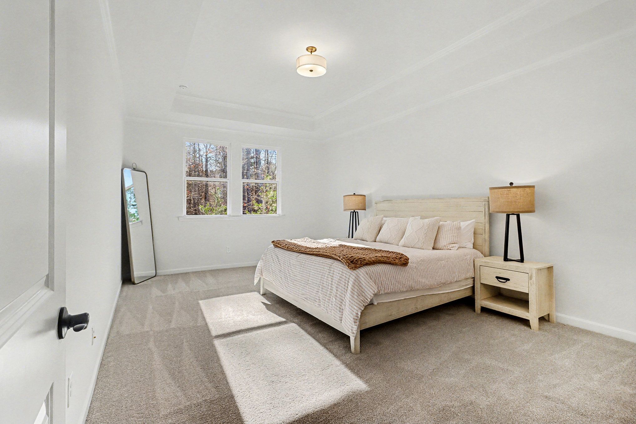 Bright secondary bedroom with ceiling fan, beige carpet, and open closet doors in Davidson Homes The Daphne B, Loganville, GA