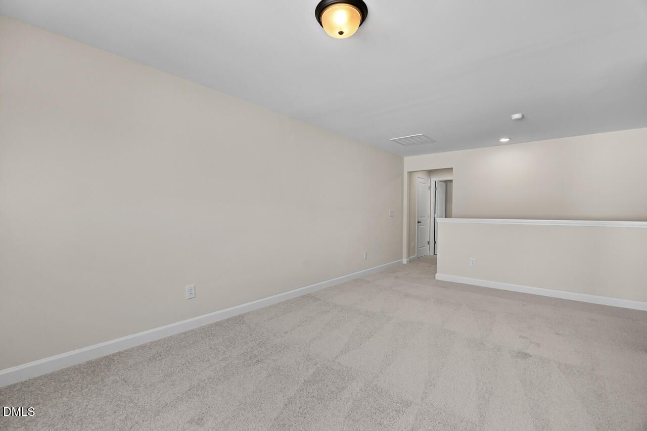Spacious carpeted bonus room with neutral walls and ceiling light in Davidson Homes The Birch II C, Sage on North Main, Wake Forest