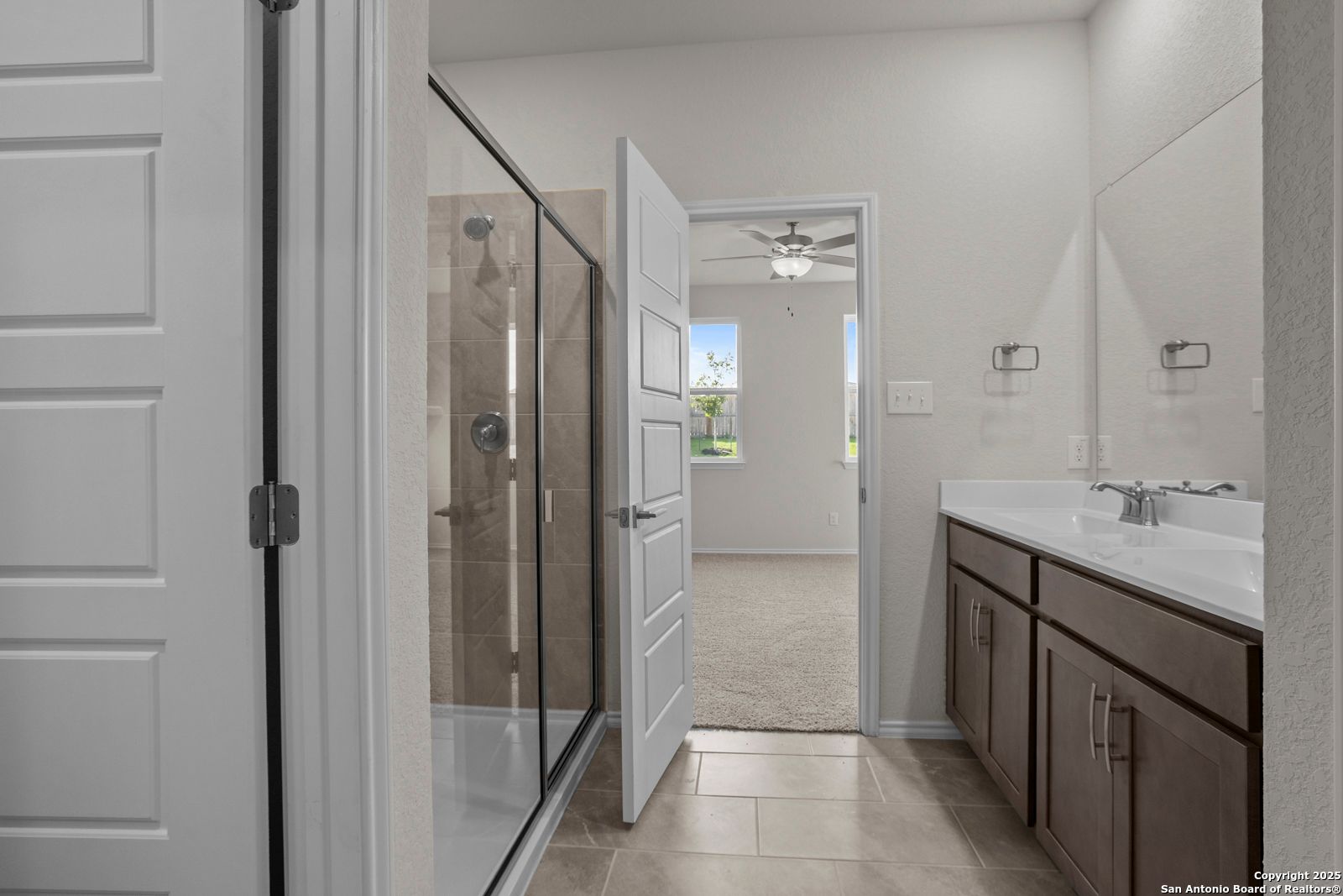 Elegant master bathroom with glass walk-in shower and double vanity in Davidson Homes The Asheville J, San Antonio, Texas