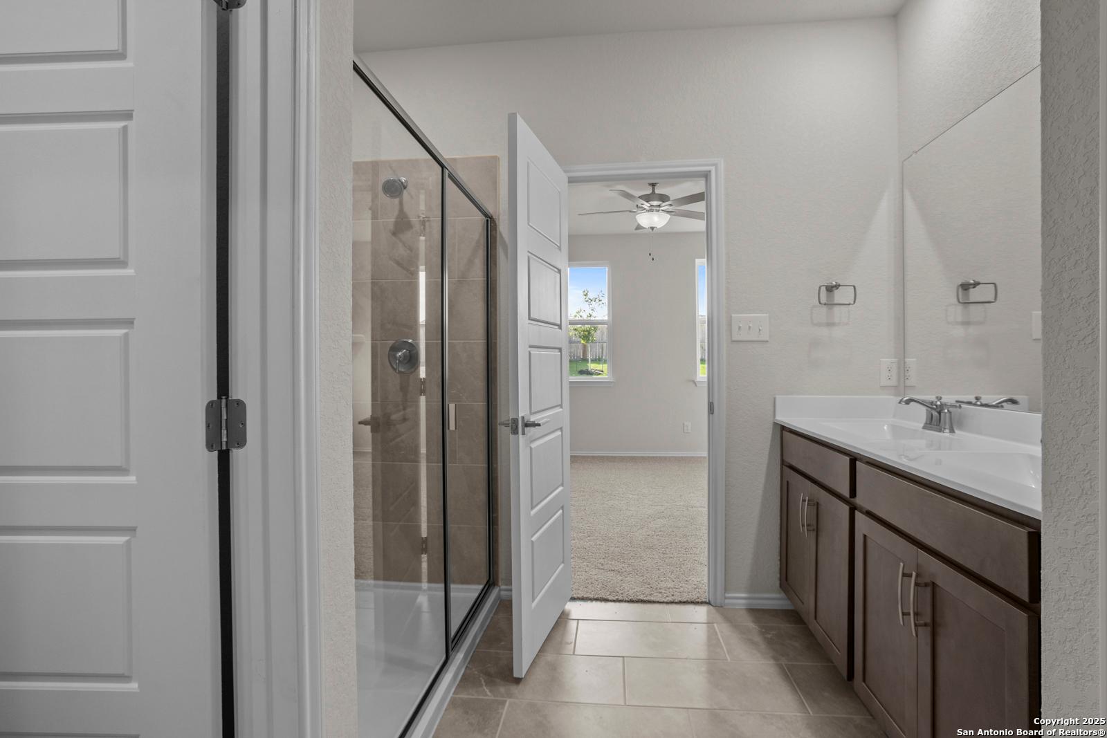 Elegant master bathroom with glass walk-in shower and double vanity in Davidson Homes The Asheville J, San Antonio, Texas
